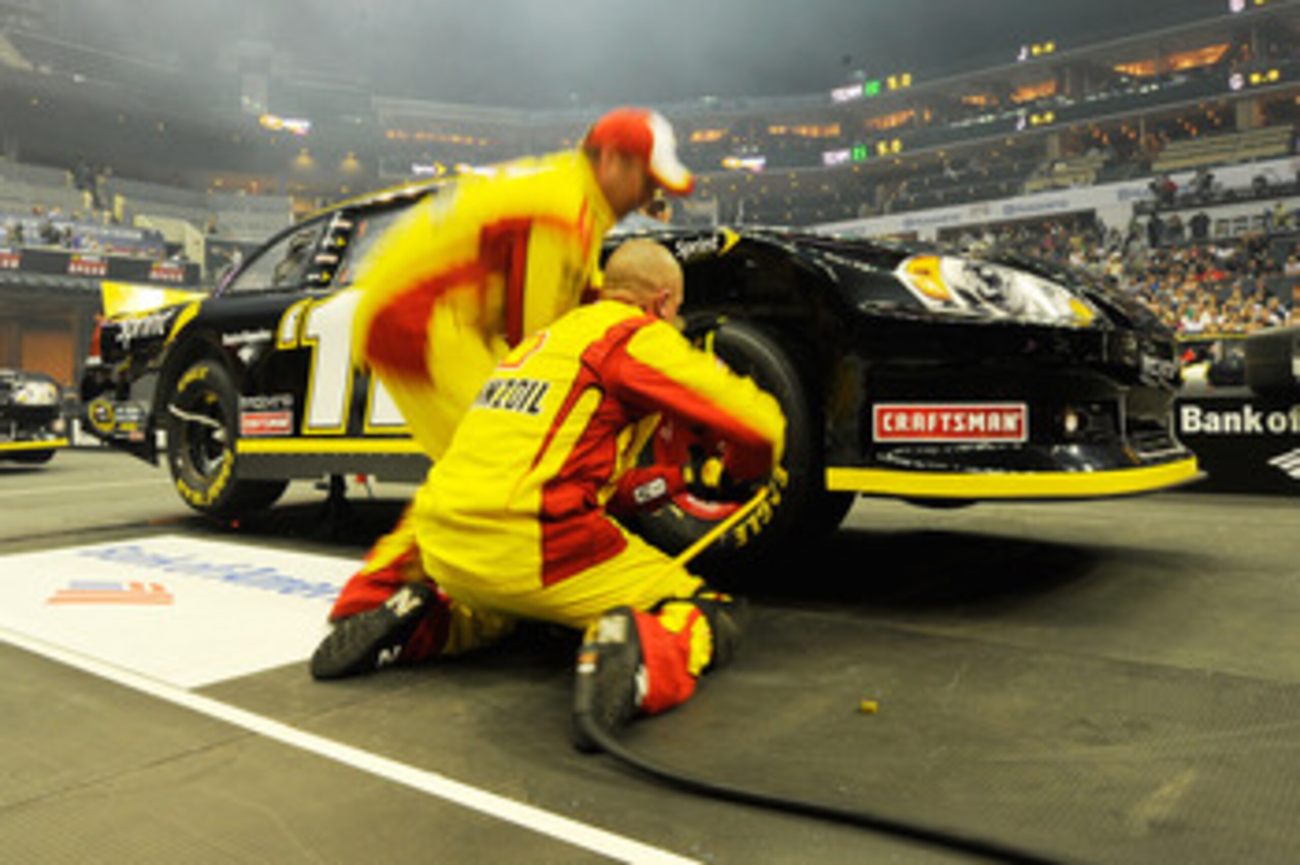 CHARLOTTE, NC - MAY 19:  Crew members for the #22 Shell/Pennzoil Dodge change a tire during the NASCAR Sprint Pit Crew Challenge at Time Warner Cable Arena on May 19, 2011 in Charlotte, North Carolina.  (Photo by Jared C. Tilton/Getty Images for NASCAR)