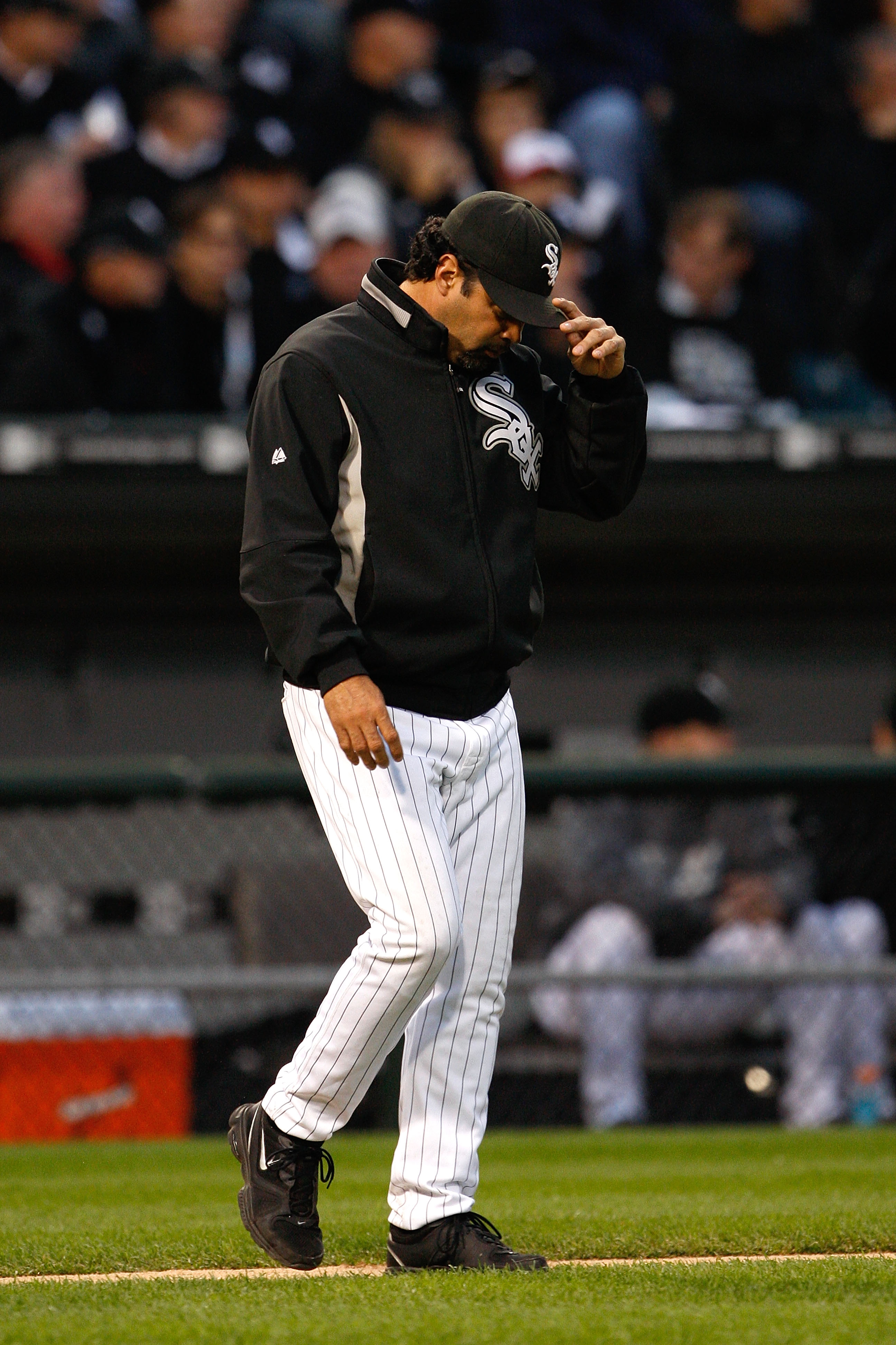 CHICAGO - OCTOBER 06:  Manager Ozzie Guillen #13 of the Chicago White Sox walks out to the mound with his head down against the Tampa Bay Rays in Game Four of the ALDS during the 2008 MLB Playoffs at U.S. Cellular Field on October 6, 2008 in Chicago, Illi