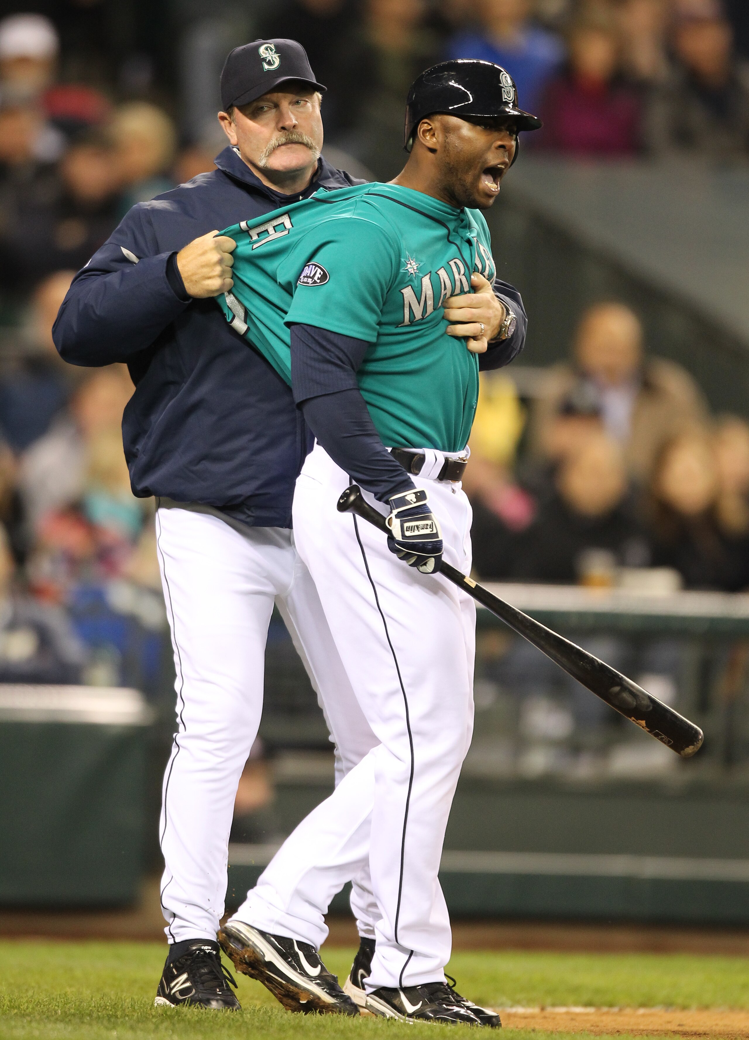 SEATTLE - MAY 06:  Milton Bradley #15 of the Seattle Mariners is restrained by manager Eric Wedge #22 after being ejected from the game against the Chicago White Sox at Safeco Field on May 6, 2011 in Seattle, Washington. The Mariners won 3-2. (Photo by Ot