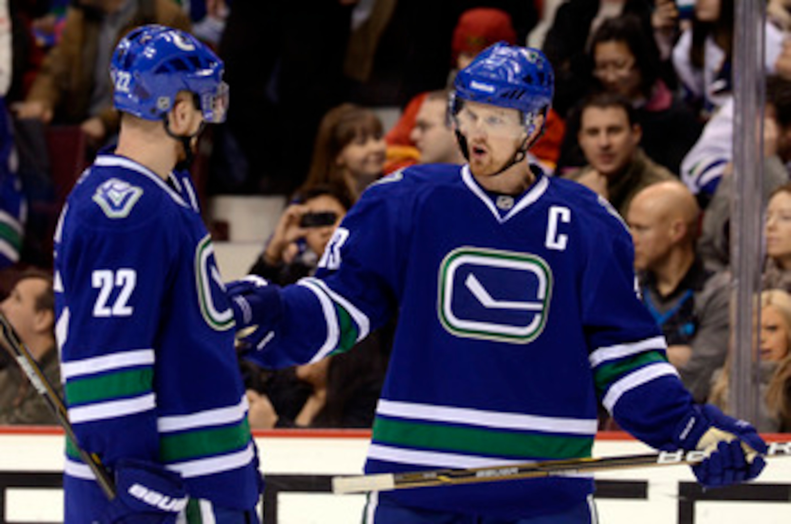 VANCOUVER, CANADA - FEBRUARY 12:  Brothers Daniel Sedin #22 and Henrik Sedin #33 of the Vancouver Canucks talk during a break in in NHL action against the Calgary Flames on February 12, 2011 at Rogers Arena in Vancouver, British Columbia, Canada.  (Photo 