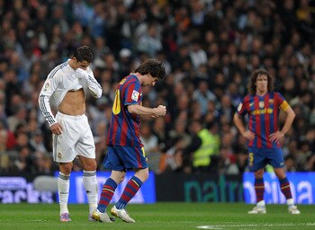 MADRID, SPAIN - APRIL 10:  Lionel Messi (R) of FC Barcelona clenches his fists celebrating scoring his sides opening goal backdropped by Cristiano Ronaldo of Real Madrid during the La Liga match between Real Madrid and Barcelona at the Estadio Santiago Be