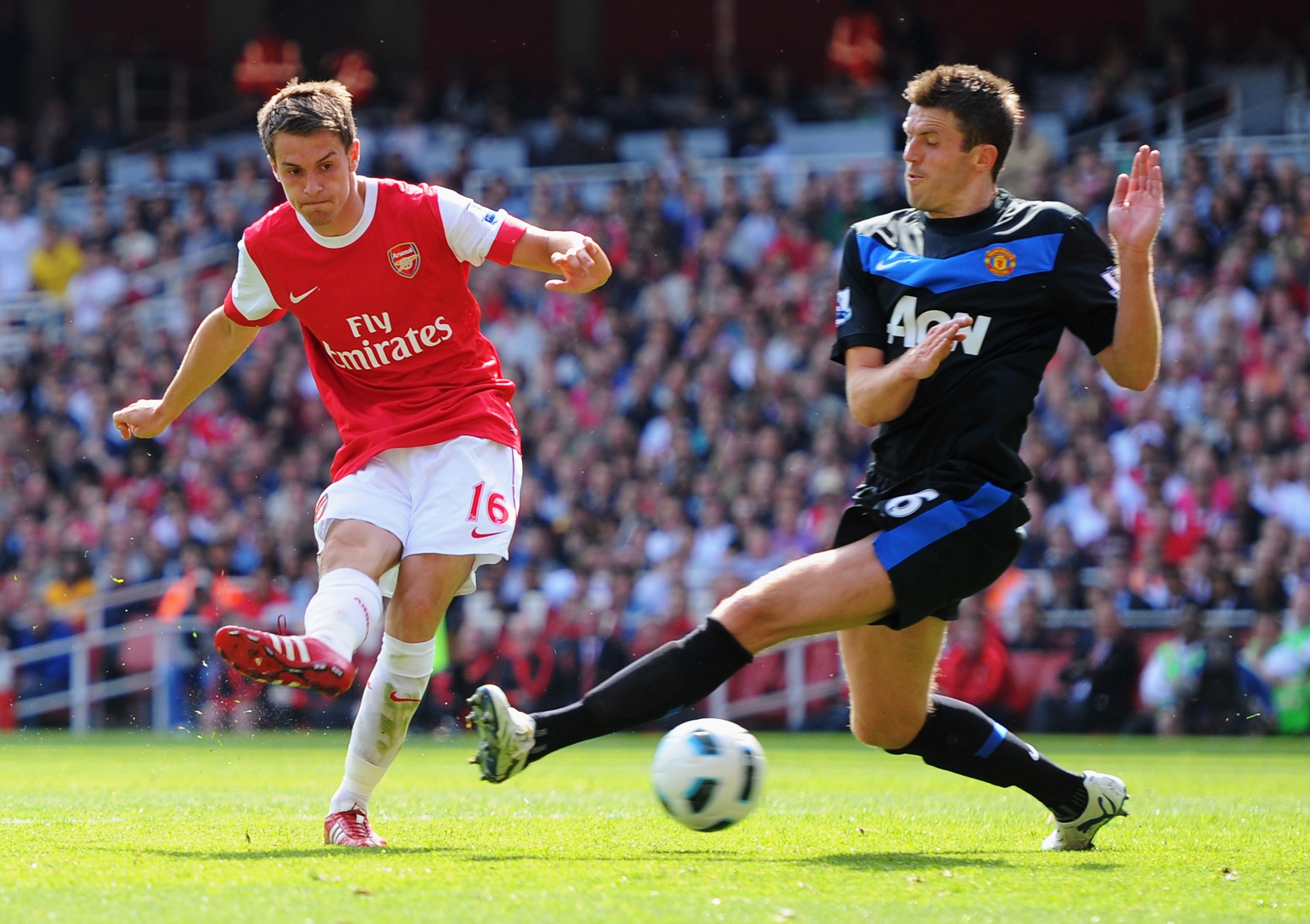LONDON, ENGLAND - MAY 01:  Aaron Ramsey of Arsenal shoots past Michael Carrick of MAnchester United to score their first goal during the Barclays Premier League match between Arsenal and Manchester United at the Emirates Stadium on May 1, 2011 in London,