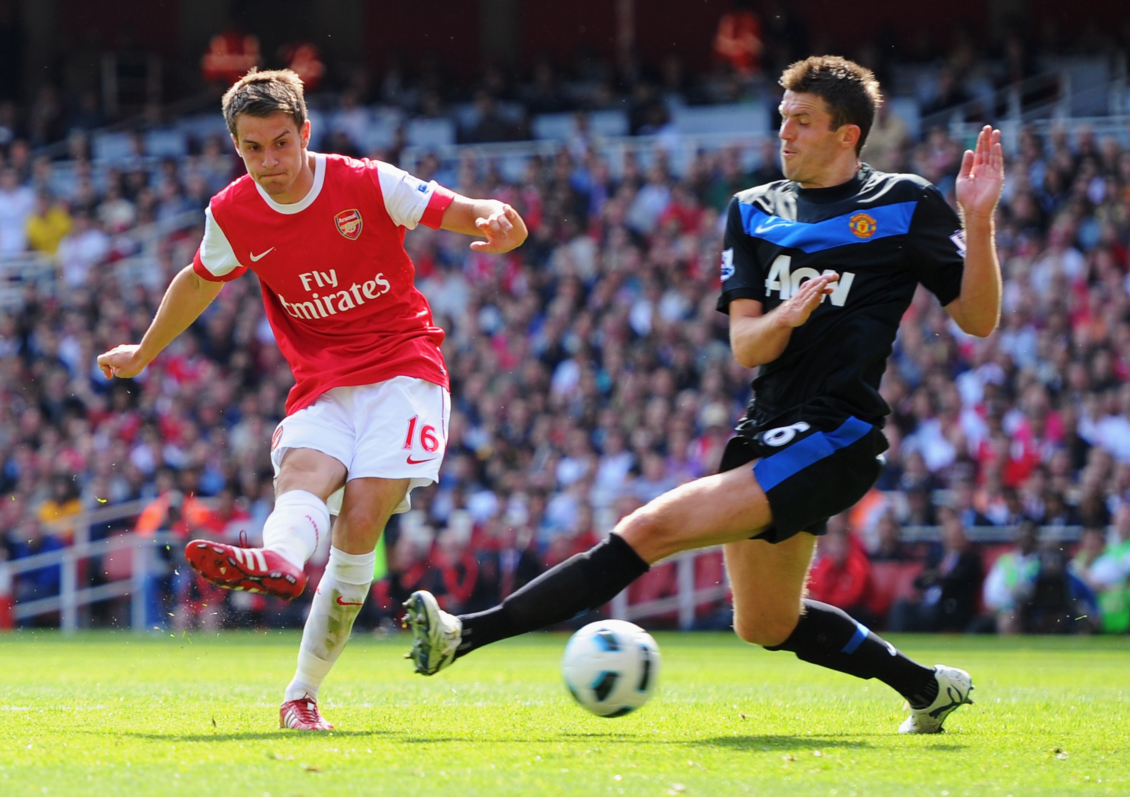 LONDON, ENGLAND - MAY 01: Aaron Ramsey of Arsenal shoots past Michael Carrick of MAnchester United to score their first goal during the Barclays Premier League match between Arsenal and Manchester United at the Emirates Stadium on May 1, 2011 in London, LONDON, ENGLAND - MAY 01: Aaron Ramsey of Arsenal shoots past Michael Carrick of MAnchester United to score their first goal during the Barclays Premier League match between Arsenal and Manchester United at the Emirates Stadium on May 1, 2011 in London,