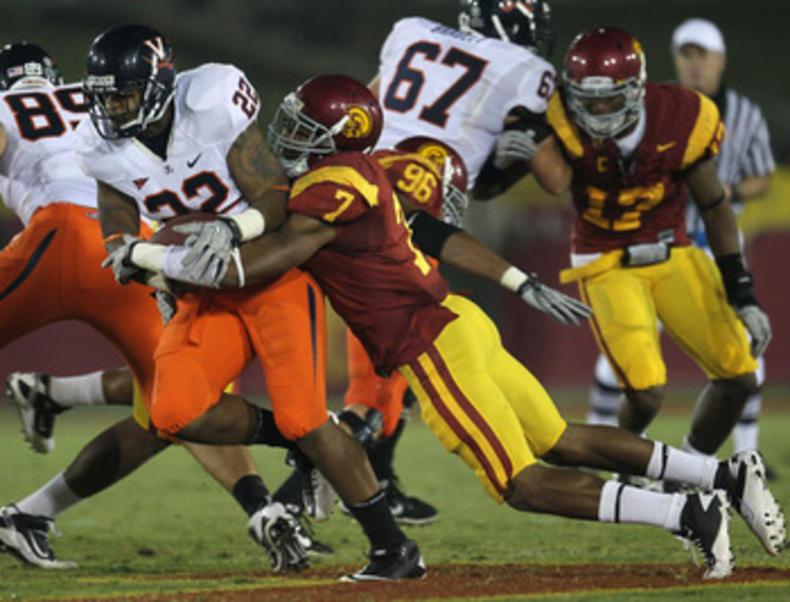 LOS ANGELES, CA - SEPTEMBER 11:  Safety T.J. McDonald #7 of the USC Trojans tackles running back Keith Payne #22 of the Virginia Cavaliers at Los Angeles Memorial Coliseum on September 11, 2010 in Los Angeles, California.  (Photo by Stephen Dunn/Getty Ima