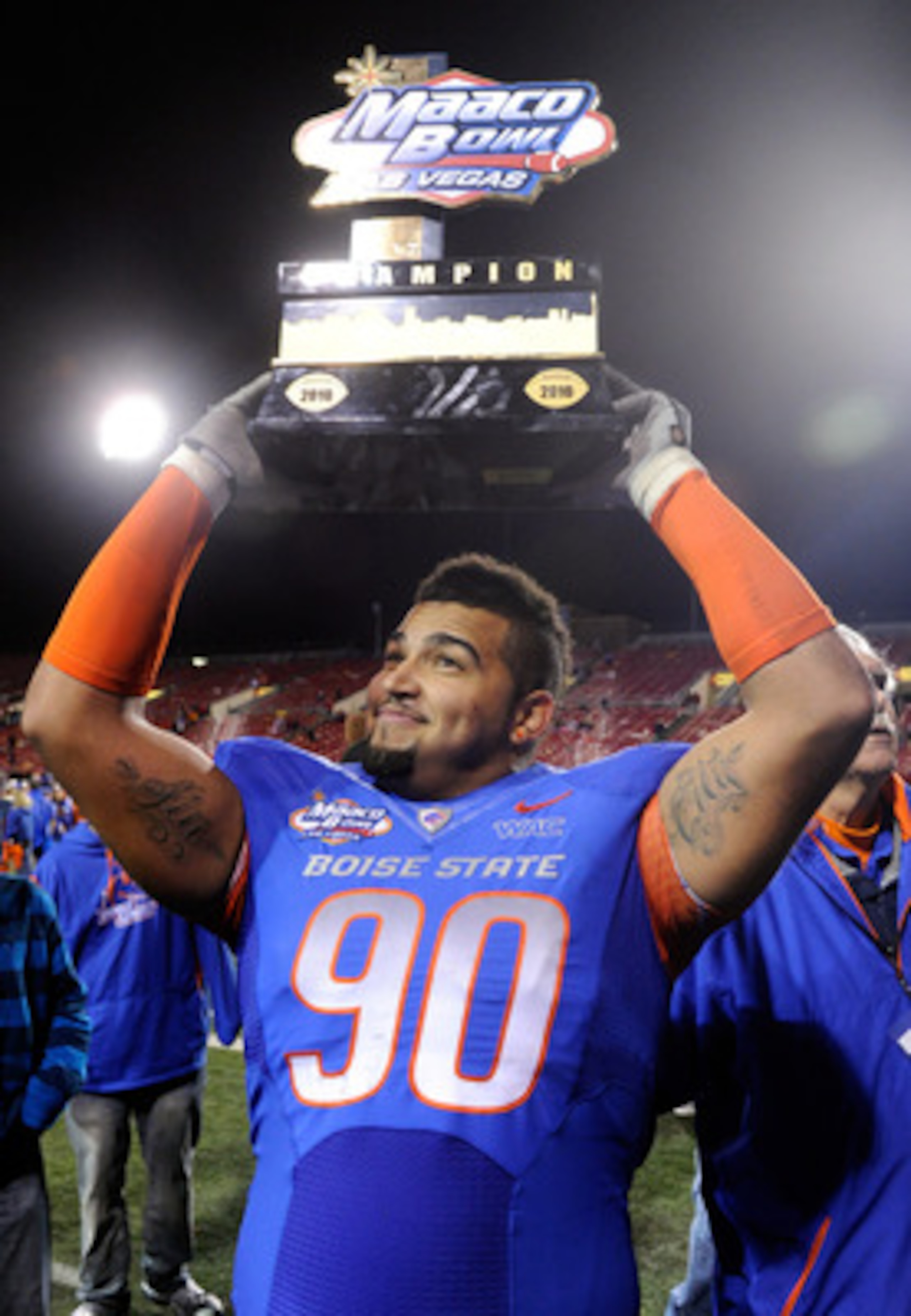 LAS VEGAS, NV - DECEMBER 22:  Billy Winn #90 of the Boise State Broncos holds up a trophy as he celebrates the team's 26-3 victory over the Utah Utes in the MAACO Bowl Las Vegas at Sam Boyd Stadium December 22, 2010 in Las Vegas, Nevada.  (Photo by Ethan