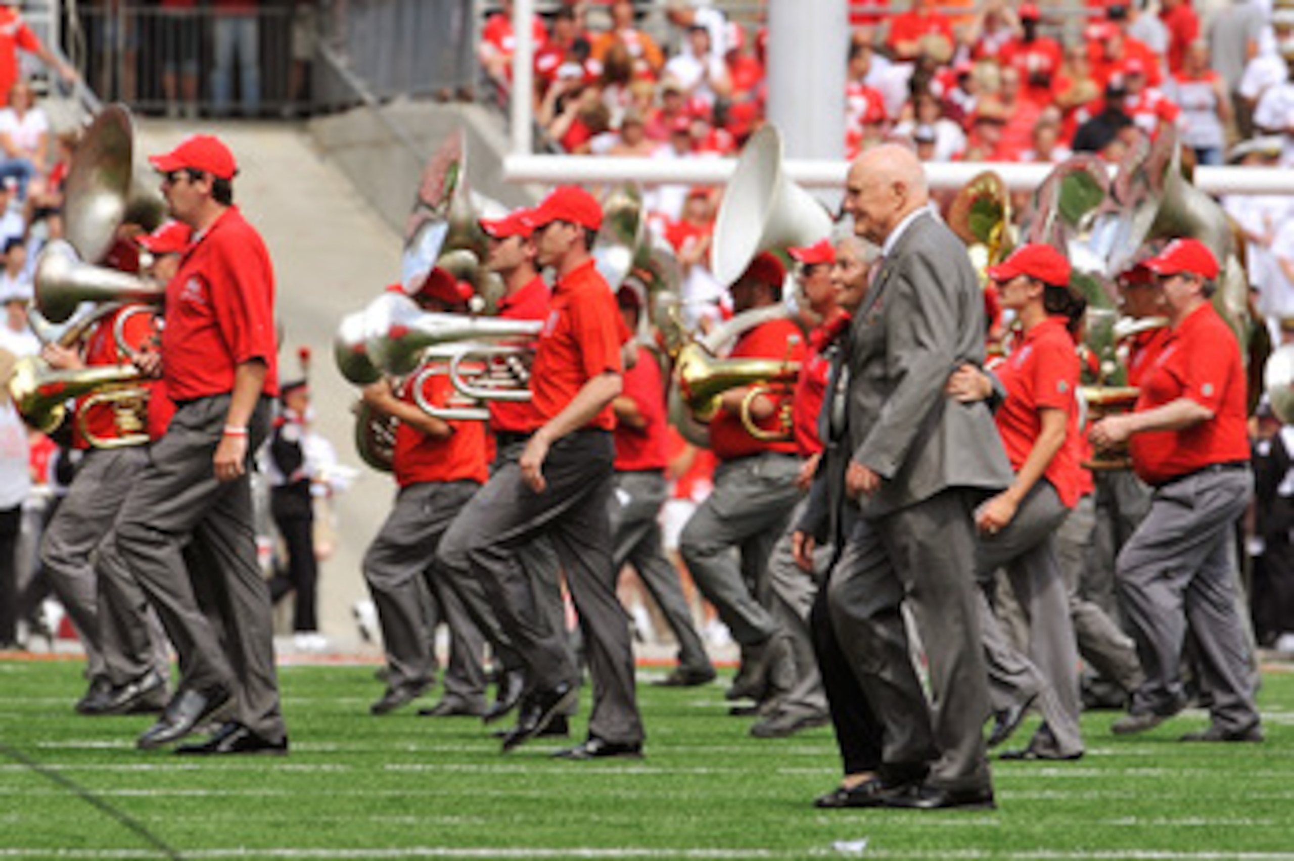 COLUMBUS, OH - SEPTEMBER 05:  Former U.S. Senator John Glenn (D-OH) and his wife Annie Glenn walk off the field after dotting the 'i' as the Ohio State Alumni Marching Band forms script Ohio during halftime of a game against the Navy Midshipmen at Ohio St