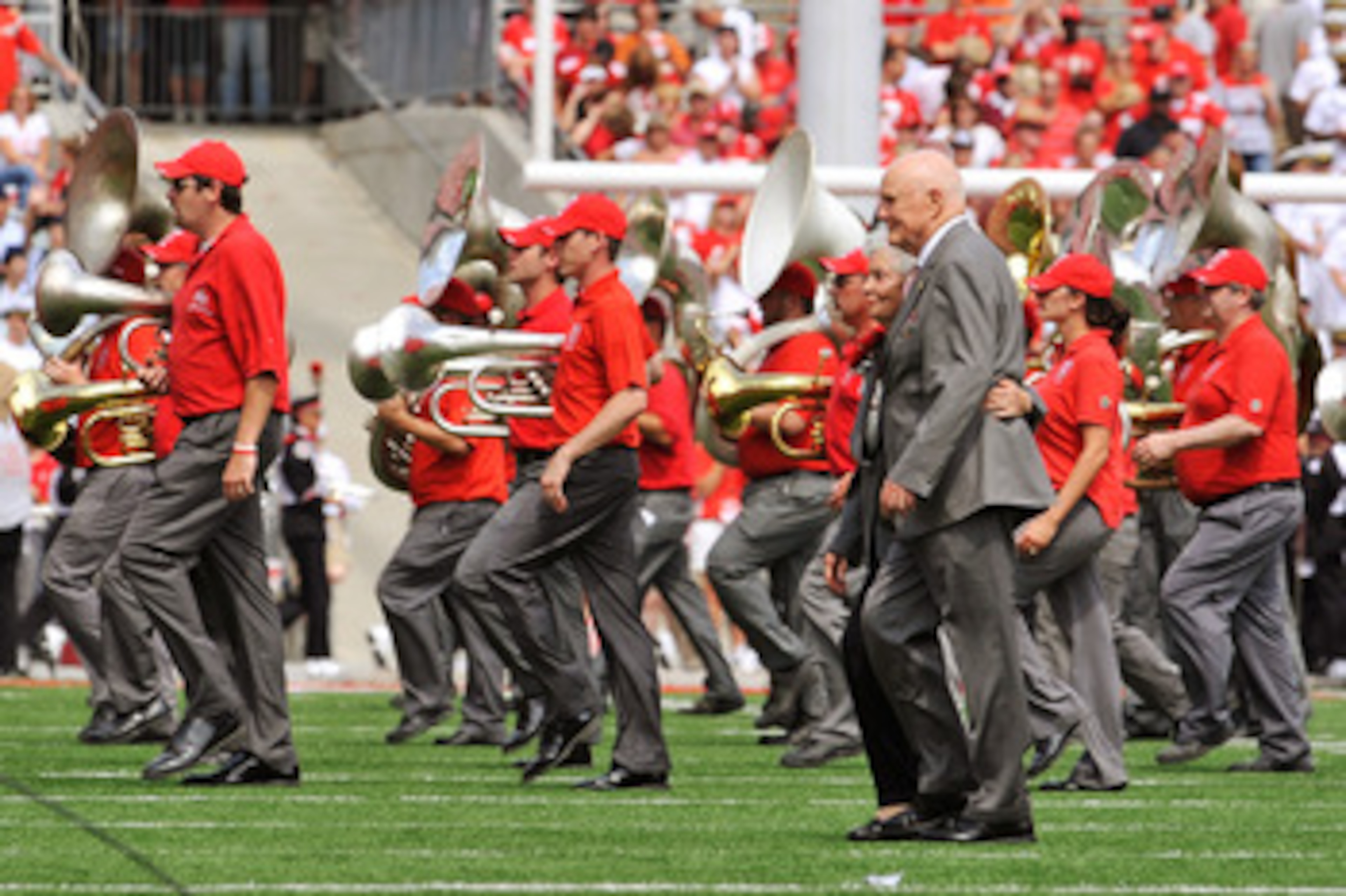 COLUMBUS, OH - SEPTEMBER 05:  Former U.S. Senator John Glenn (D-OH) and his wife Annie Glenn walk off the field after dotting the 'i' as the Ohio State Alumni Marching Band forms script Ohio during halftime of a game against the Navy Midshipmen at Ohio St