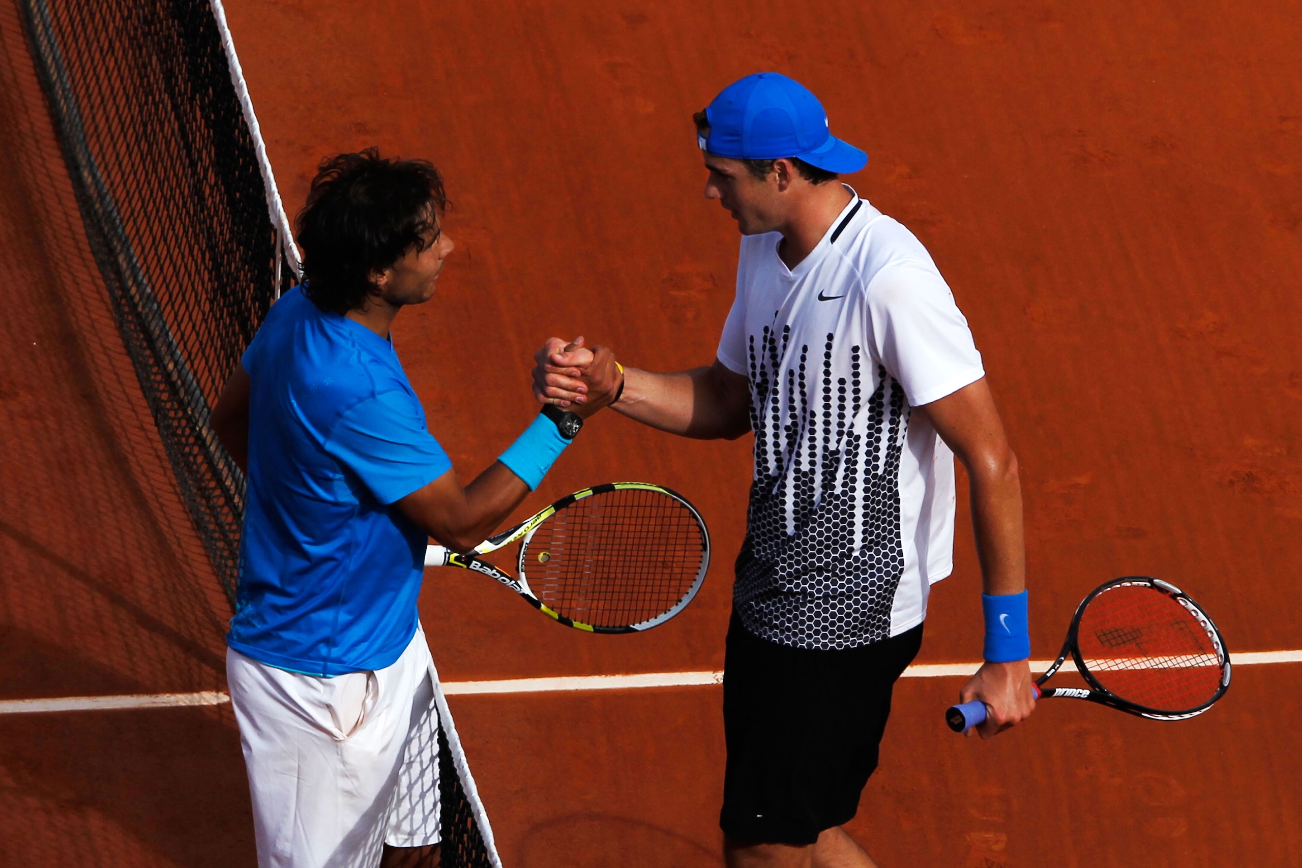 PARIS, FRANCE - MAY 24:  Rafael Nadal (L) of Spain shakes hands at the net with John Isner of USA after their men's singles round one match on day three of the French Open at Roland Garros on May 24, 2011 in Paris, France.  (Photo by Matthew Stockman/Gett