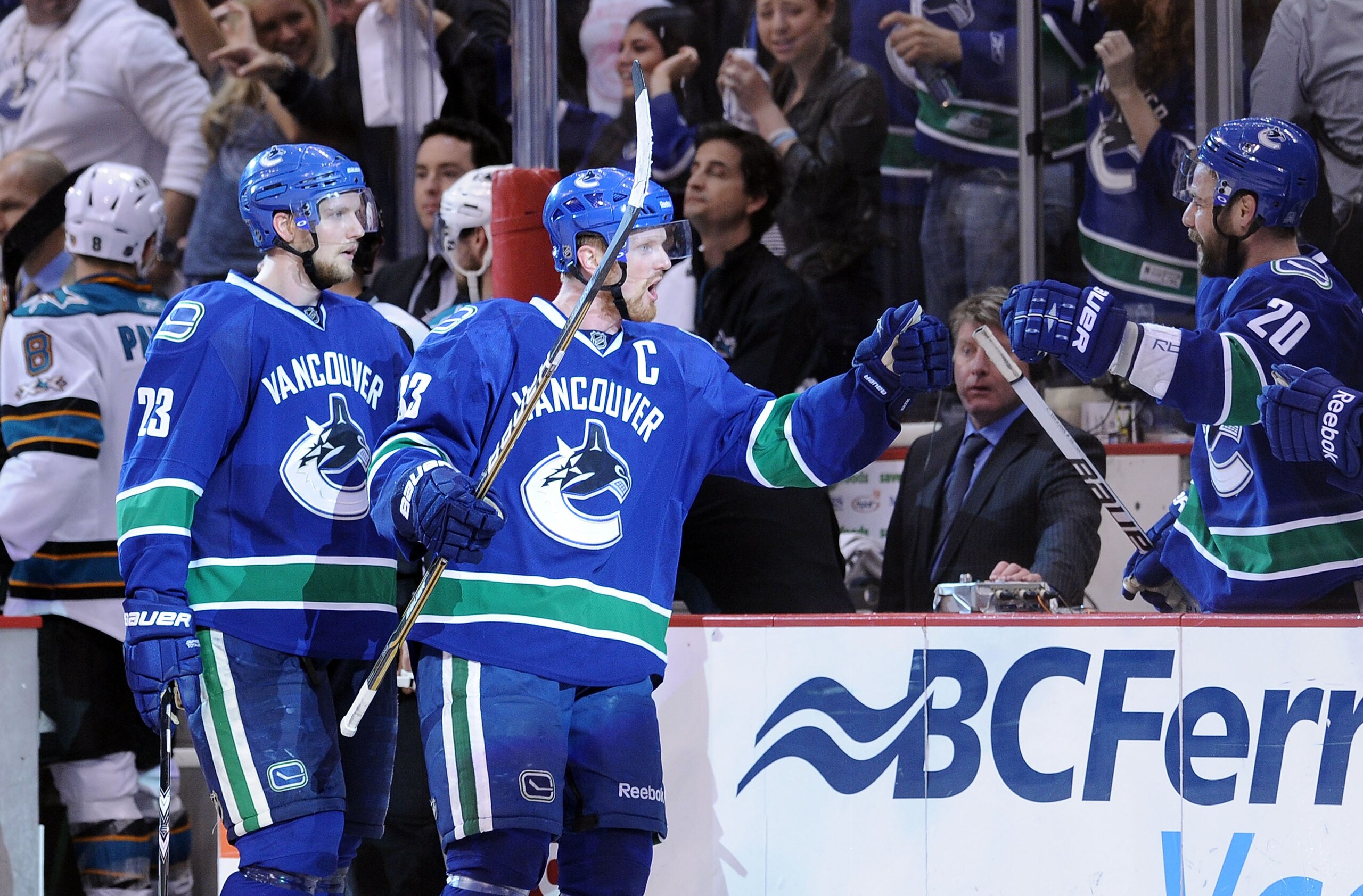 VANCOUVER, CANADA - MAY 24:  Alexander Edler #23 and Henrik Sedin #33 of the Vancouver Canucks skate by the Canucks bench to celebrate with teammates after Kesler's game-tying goal late in the third period to send the game into overtime in Game Five of th