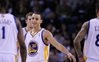 OAKLAND, CA - MARCH 25:  Stephen Curry #30 of the Golden State Warriors congratulates his teammates during their game against the Toronto Raptors at Oracle Arena on March 25, 2011 in Oakland, California. NOTE TO USER: User expressly acknowledges and agree