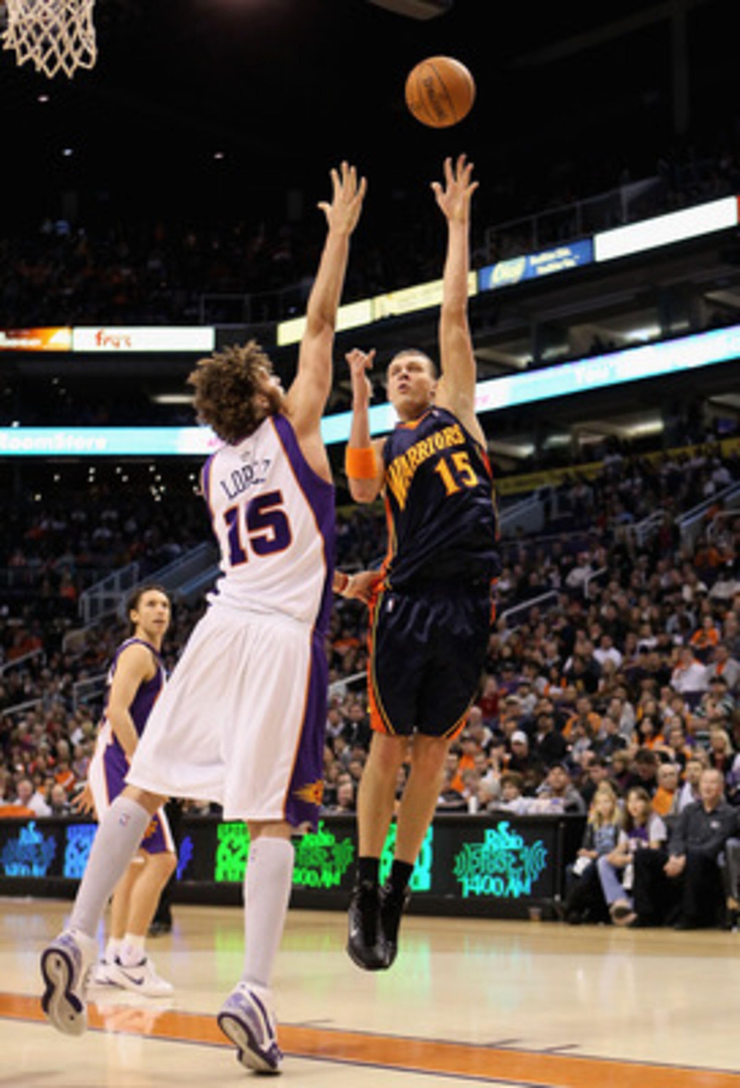 PHOENIX - JANUARY 23:  Andris Biedrins #15 of the Golden State Warriors lays up a shot over Robin Lopez #15 of the Phoenix Suns during the NBA game at US Airways Center on January 23, 2010 in Phoenix, Arizona. NOTE TO USER: User expressly acknowledges and