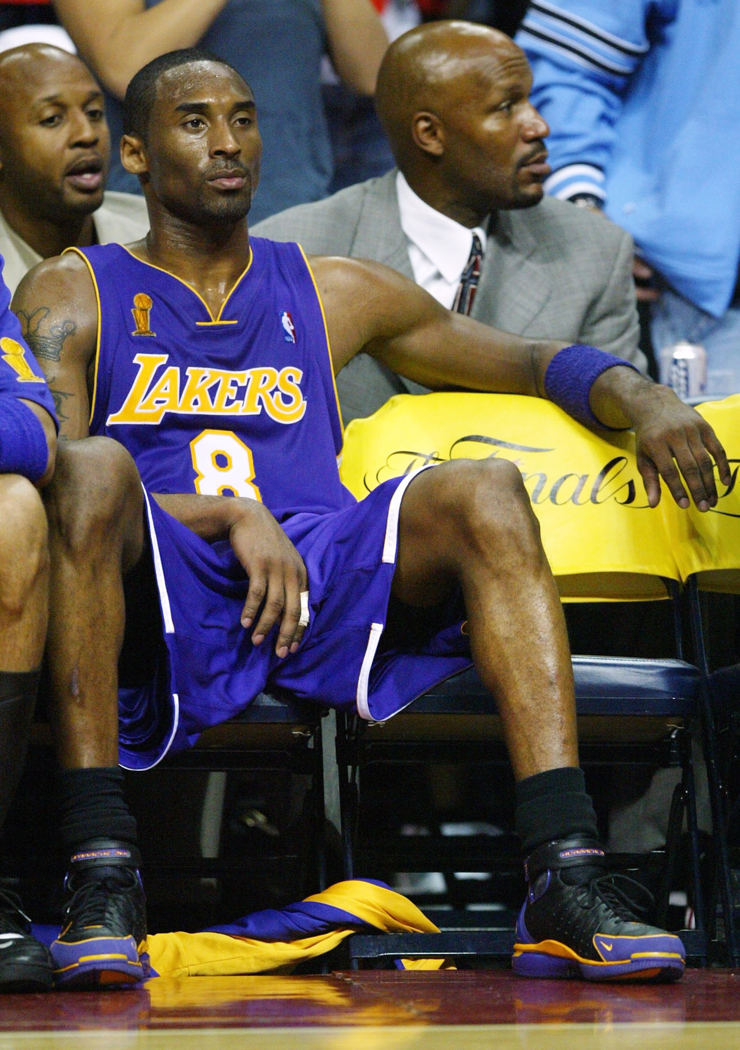 AUBURN HILLS, MI - JUNE 10: Kobe Bryant #8 of the Los Angeles Lakers sits on the bench in front of former Lakers Brian Shaw (back-L) and Ron Harper (back-R) during a time-out in the fourth quarter of game three of the 2004 NBA Finals against the Detroit AUBURN HILLS, MI - JUNE 10: Kobe Bryant #8 of the Los Angeles Lakers sits on the bench in front of former Lakers Brian Shaw (back-L) and Ron Harper (back-R) during a time-out in the fourth quarter of game three of the 2004 NBA Finals against the Detroit