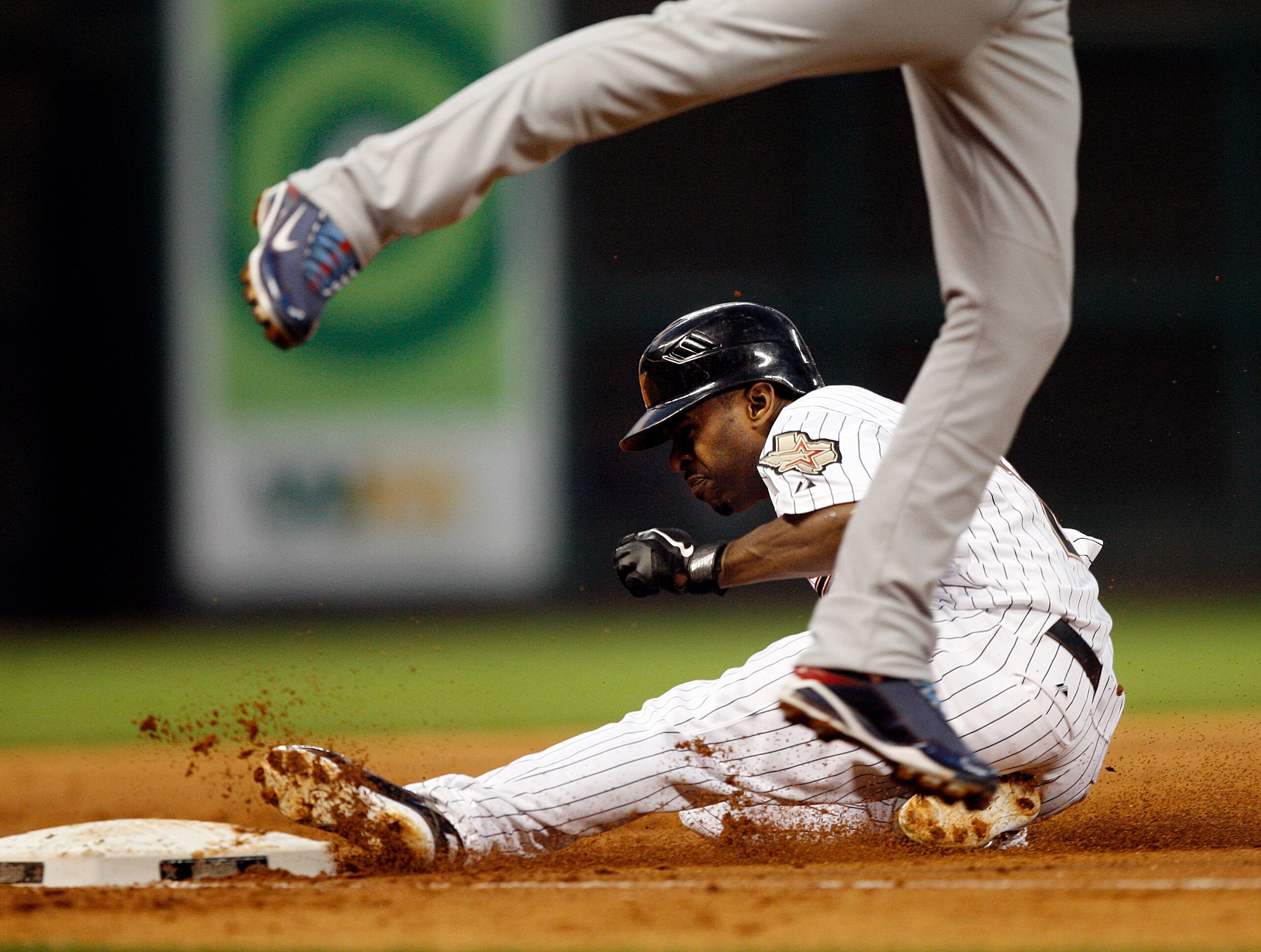 HOUSTON - APRIL 12:  Houston Astros' Michael Bourn #21 steals third base against the Chicago Cubs at Minute Maid Park on April 12, 2011 in Houston, Texas.  (Photo by Bob Levey/Getty Images)