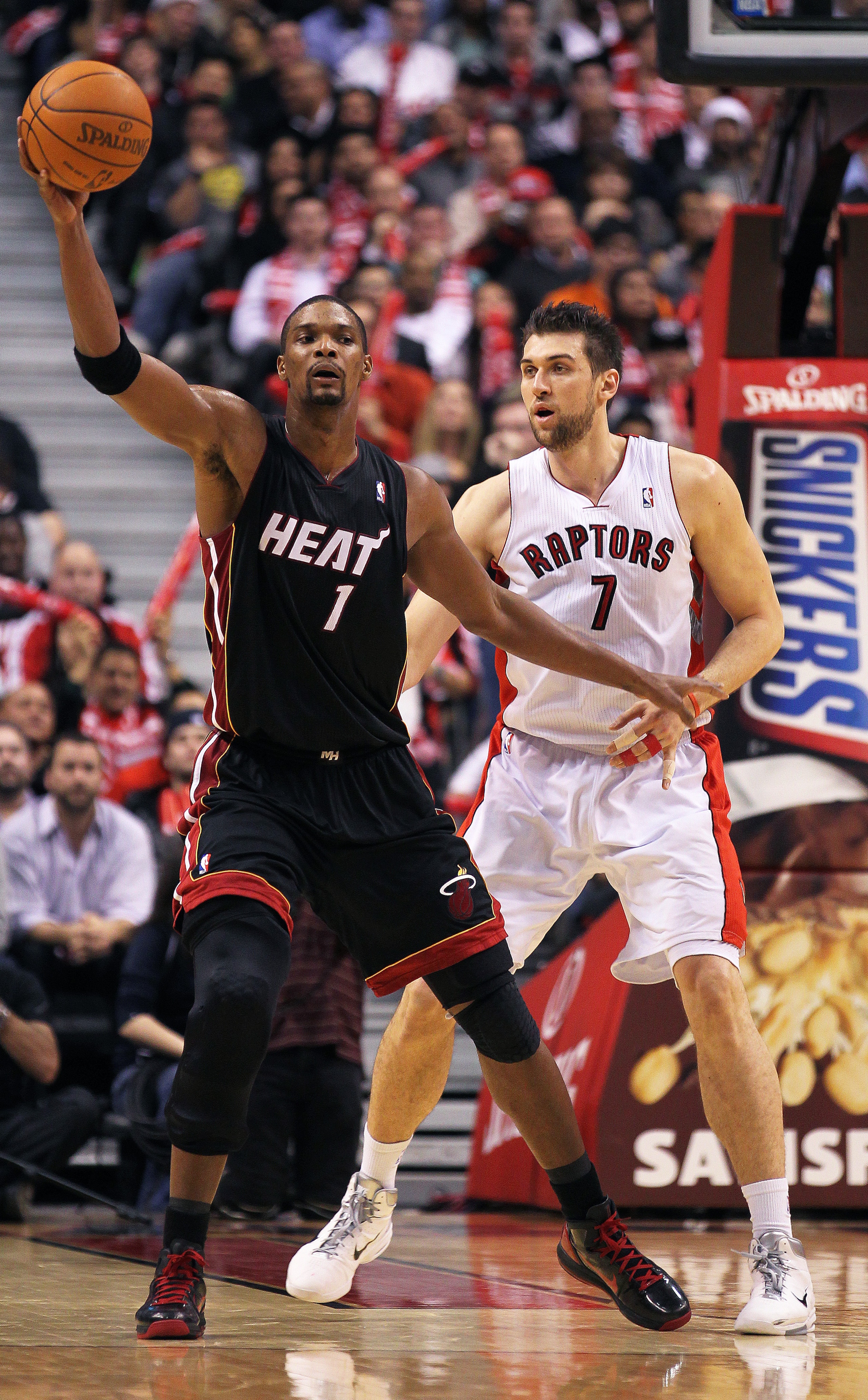TORONTO, CAN - FEBRUARY 16:  Chris Bosh #1 of the Miami Heat tries to keep the ball away from a defending Andrea Bargnani #7 of the Toronto Raptors in a game on February 16, 2011 at the Air Canada Centre in Toronto, Canada. The Heat defeated the Raptors 1