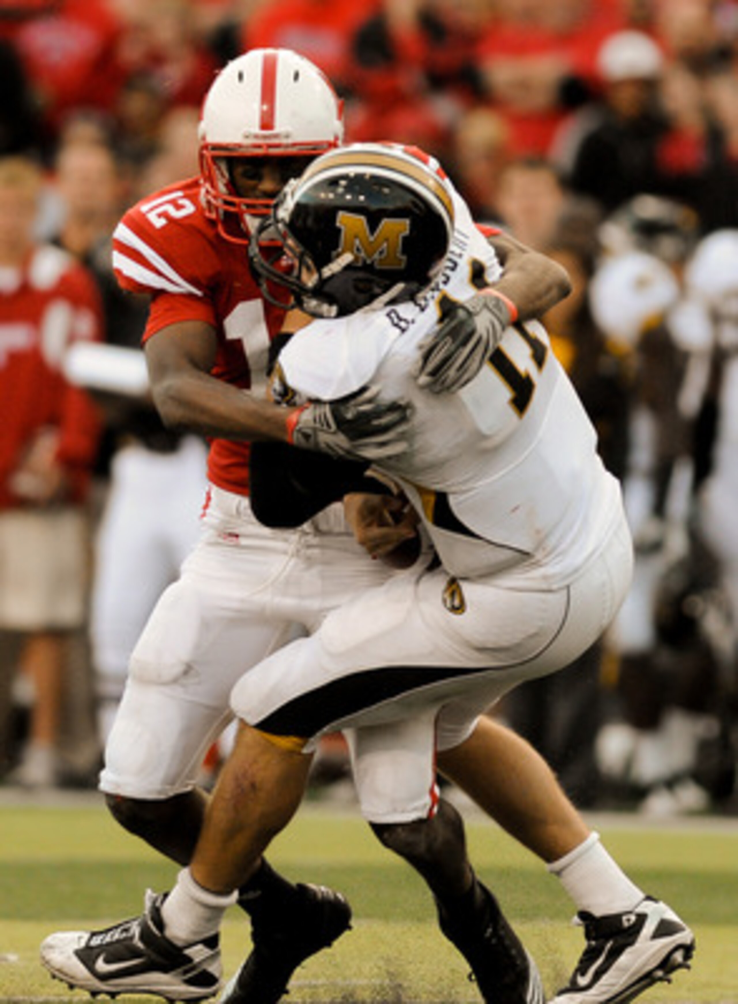 LINCOLN, NE - OCTOBER 30: Safety Courtney Osborne #12 of the Nebraska Cornhuskers hits  quarterback Blaine Gabbert #11 of the Missouri Tigers during second half action of their game at Memorial Stadium on October 30, 2010 in Lincoln, Nebraska. Nebraska De