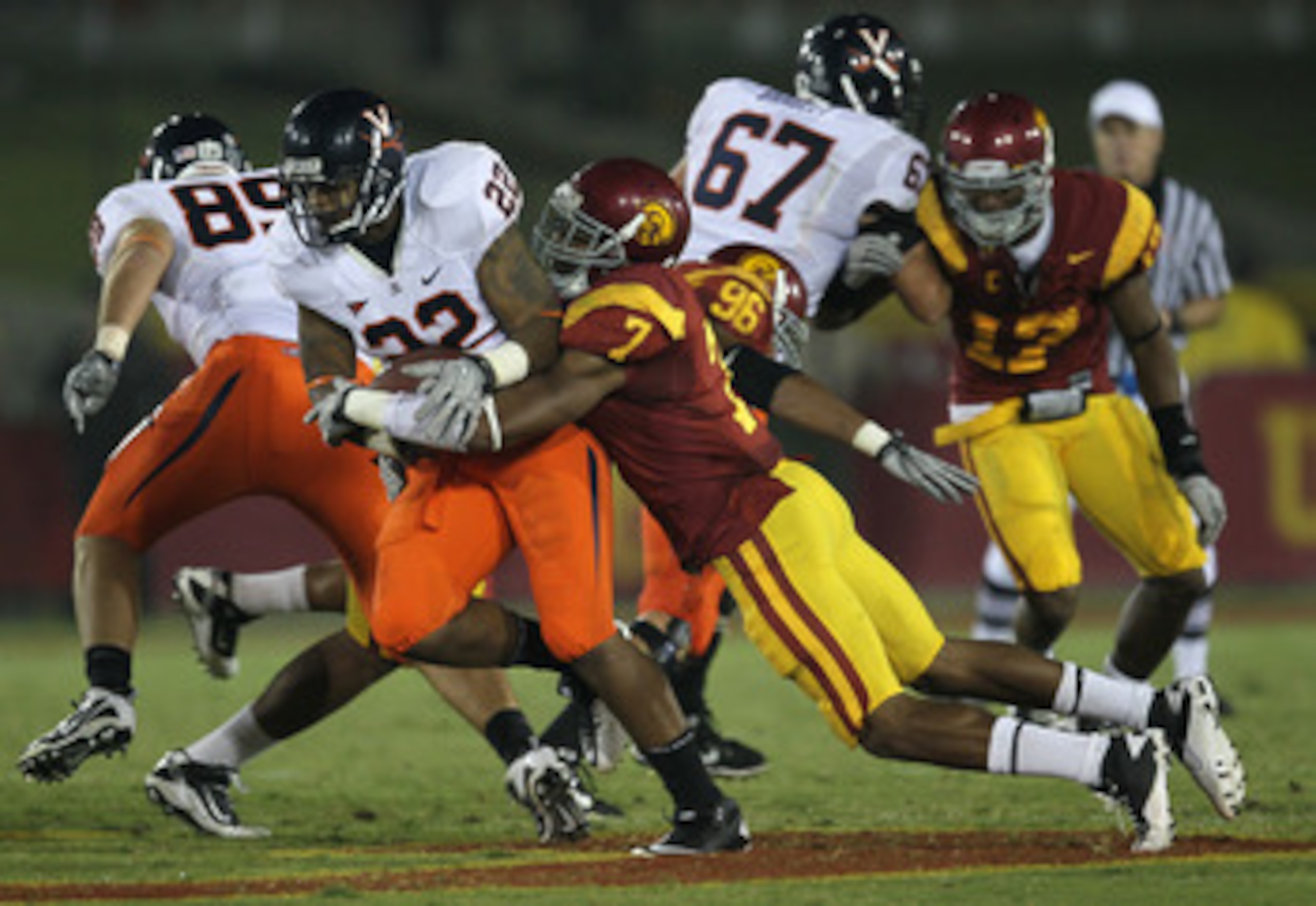 LOS ANGELES, CA - SEPTEMBER 11:  Safety T.J. McDonald #7 of the USC Trojans tackles running back Keith Payne #22 of the Virginia Cavaliers at Los Angeles Memorial Coliseum on September 11, 2010 in Los Angeles, California.  (Photo by Stephen Dunn/Getty Ima