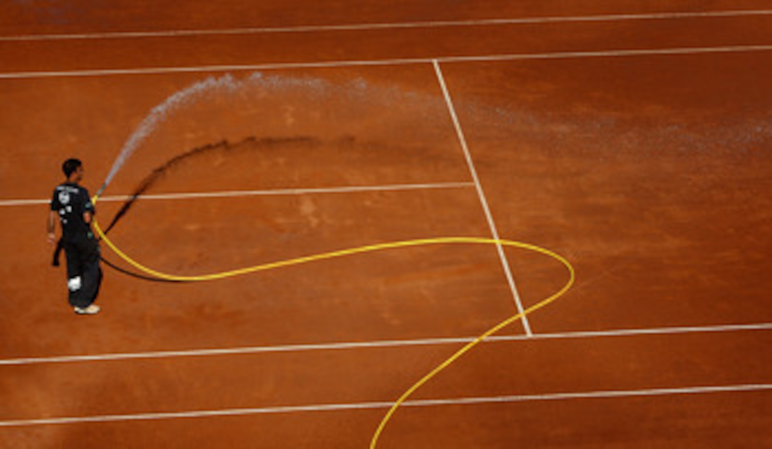 ROME - MAY 07:  A court attendant waters the dusty clay court in between games during day four of the Sony Ericsson WTA Tour Internazionli BNL D'Italia event at Foro Italico on May 7, 2009 in Rome, Italy.  (Photo by Ryan Pierse/Getty Images)