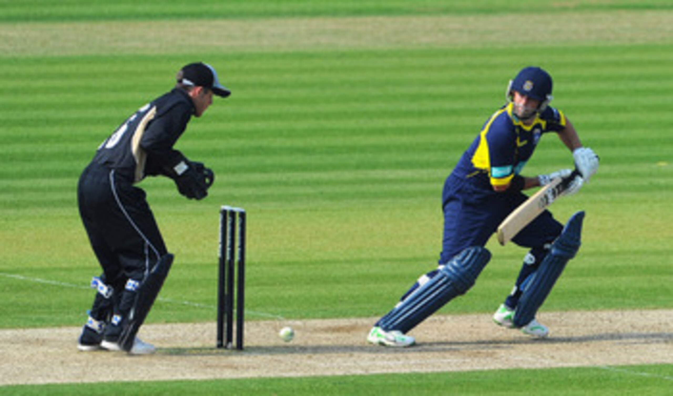 SOUTHAMPTON, ENGLAND - APRIL 24: Neil McKenzie of Hamphire strikes a boundary as wicketkeeper Richard Johnson of Warwickshire looks on during the Clydesdale Bank 40 match between Hampshire and Warwickshire at The Rose Bowl on April 24, 2011 in Southampto SOUTHAMPTON, ENGLAND - APRIL 24: Neil McKenzie of Hamphire strikes a boundary as wicketkeeper Richard Johnson of Warwickshire looks on during the Clydesdale Bank 40 match between Hampshire and Warwickshire at The Rose Bowl on April 24, 2011 in Southampto