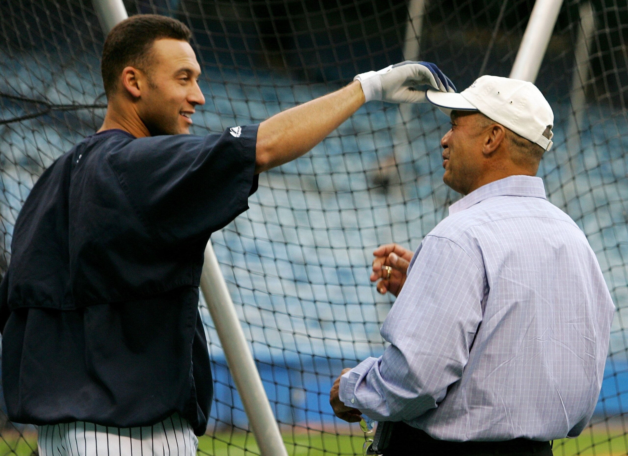 NEW YORK - SEPTEMBER 13:  Derek Jeter #2 (L) of the New York Yankees jokes with Yankee legend and Hall of Famer Reggie Jackson before playing the Tampa Bay Devil Rays on September 13, 2006 at Yankee Stadium in the Bronx borough of New York City.  (Photo b