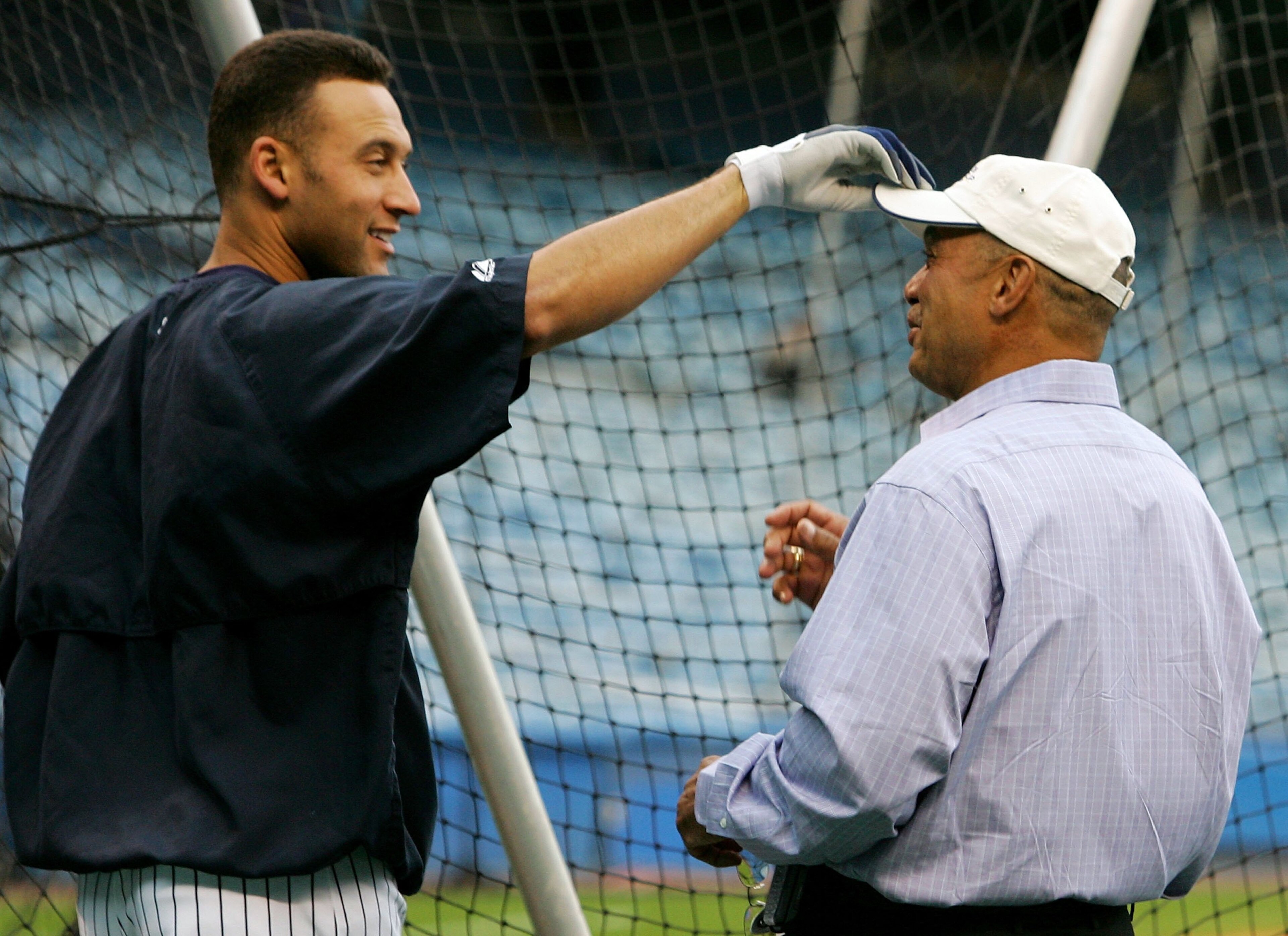 NEW YORK - SEPTEMBER 13:  Derek Jeter #2 (L) of the New York Yankees jokes with Yankee legend and Hall of Famer Reggie Jackson before playing the Tampa Bay Devil Rays on September 13, 2006 at Yankee Stadium in the Bronx borough of New York City.  (Photo b