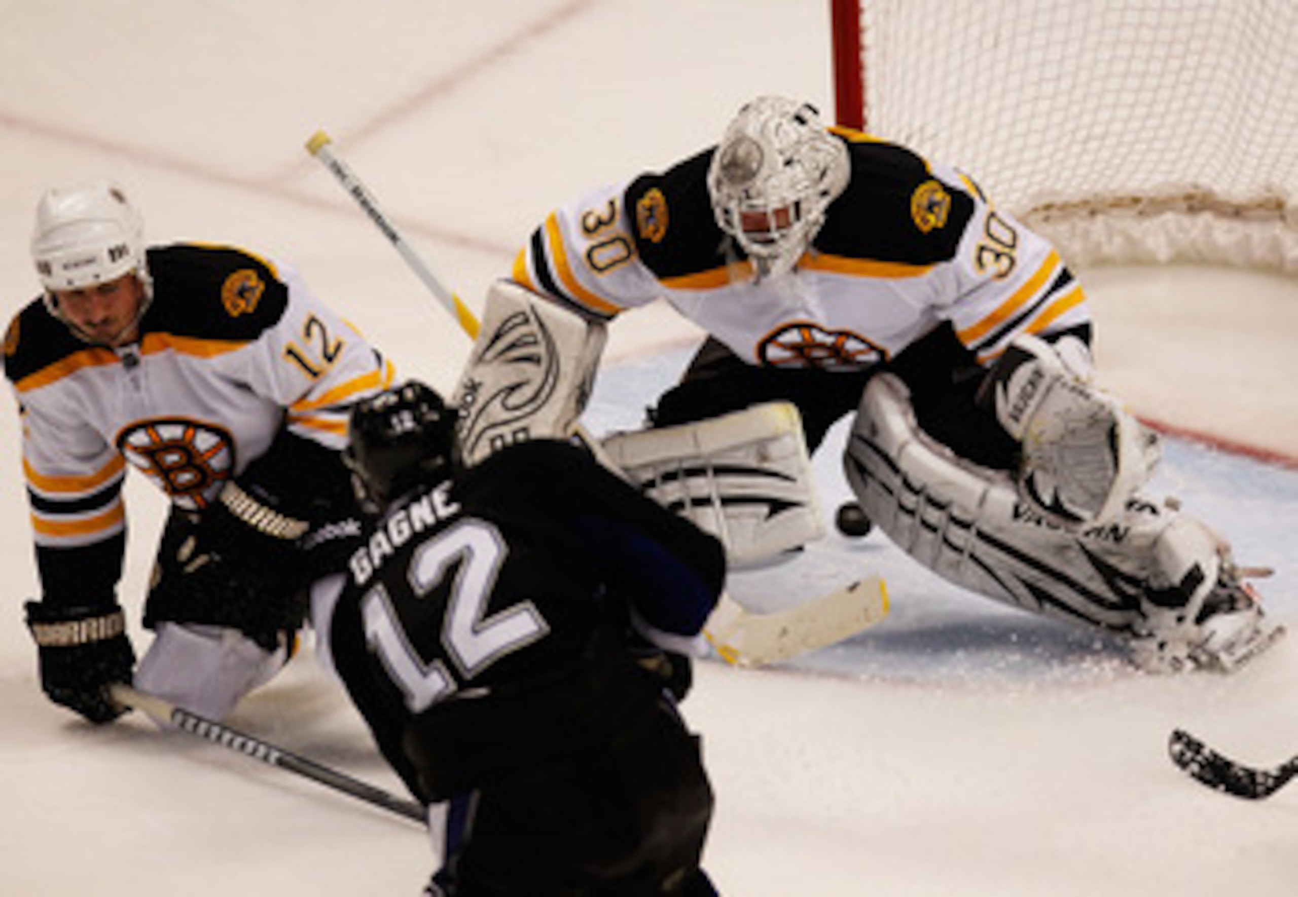 TAMPA, FL - MAY 21:  Simon Gagne #12 of the Tampa Bay Lightning scores a third period goal past Tomas Kaberle #12 and Tim Thomas #30 of the Boston Bruins in Game Four of the Eastern Conference Finals during the 2011 NHL Stanley Cup Playoffs at St Pete Tim