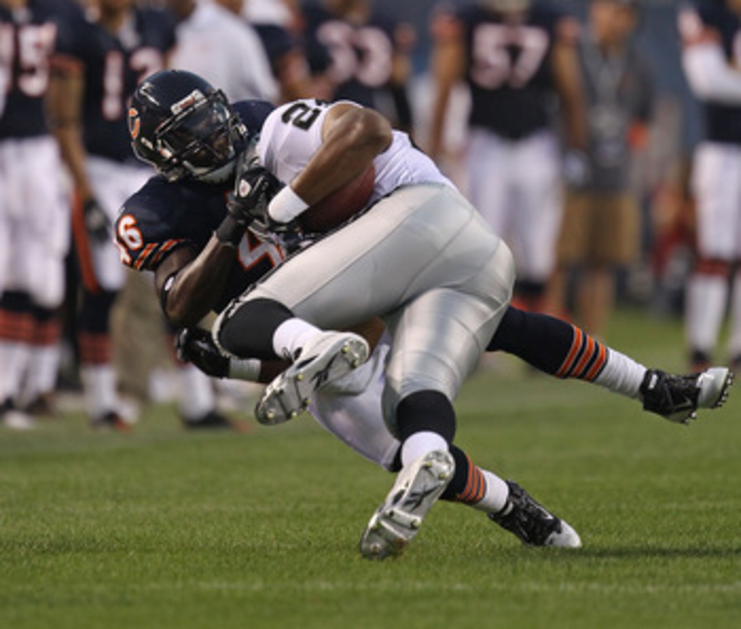 CHICAGO - AUGUST 21: Chris Harris #46 of the Chicago Bears tackles Michael Bush #29 of the Oakland Raiders during a preseason game at Soldier Field on August 21, 2010 in Chicago, Illinois. The Raiders defeated the Bears 32-17. (Photo by Jonathan Daniel/Ge