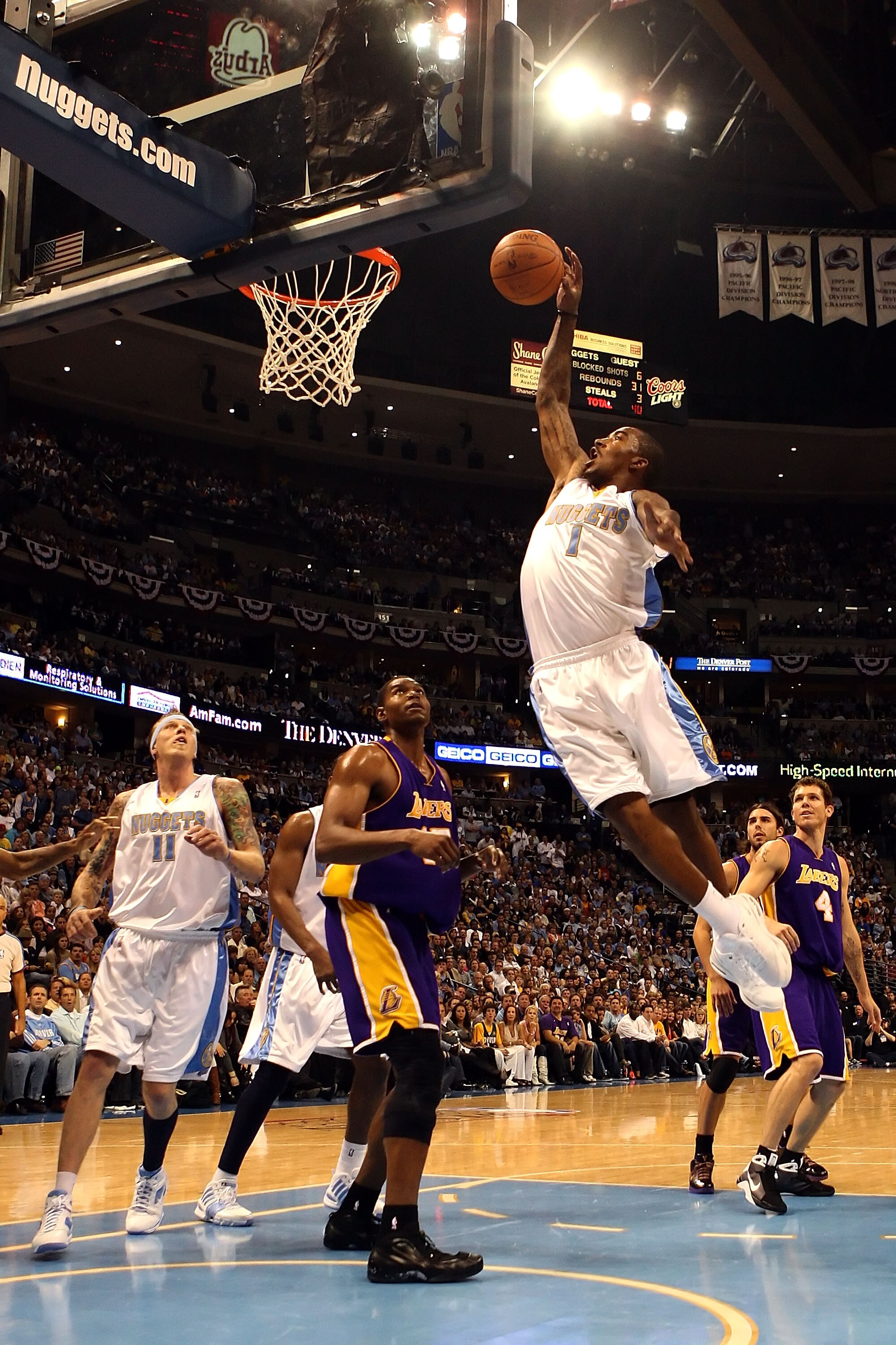 DENVER - MAY 25:  J.R. Smith #1 of the Denver Nuggets dunks the ball over Andrew Bynum #17 of the Los Angeles Lakers in Game Four of the Western Conference Finals during the 2009 NBA Playoffs at Pepsi Center on May 25, 2009 in Denver, Colorado. NOTE TO US