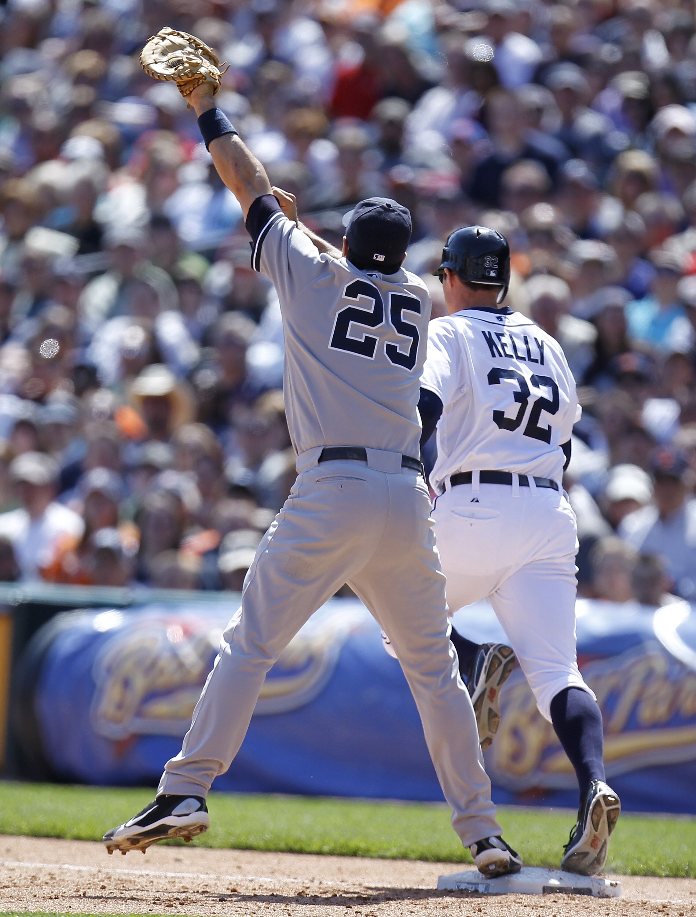 DETROIT, MI - MAY 05: Mark Teixeira #25 of the New York Yankees watches the ball go over his head from a throw by Eduardo Nunez #26 in front of Don Kelly #32 of the Detroit Tigers in the seventh inning at Comerica Park on May 5, 2011 in Detroit, Michigan.