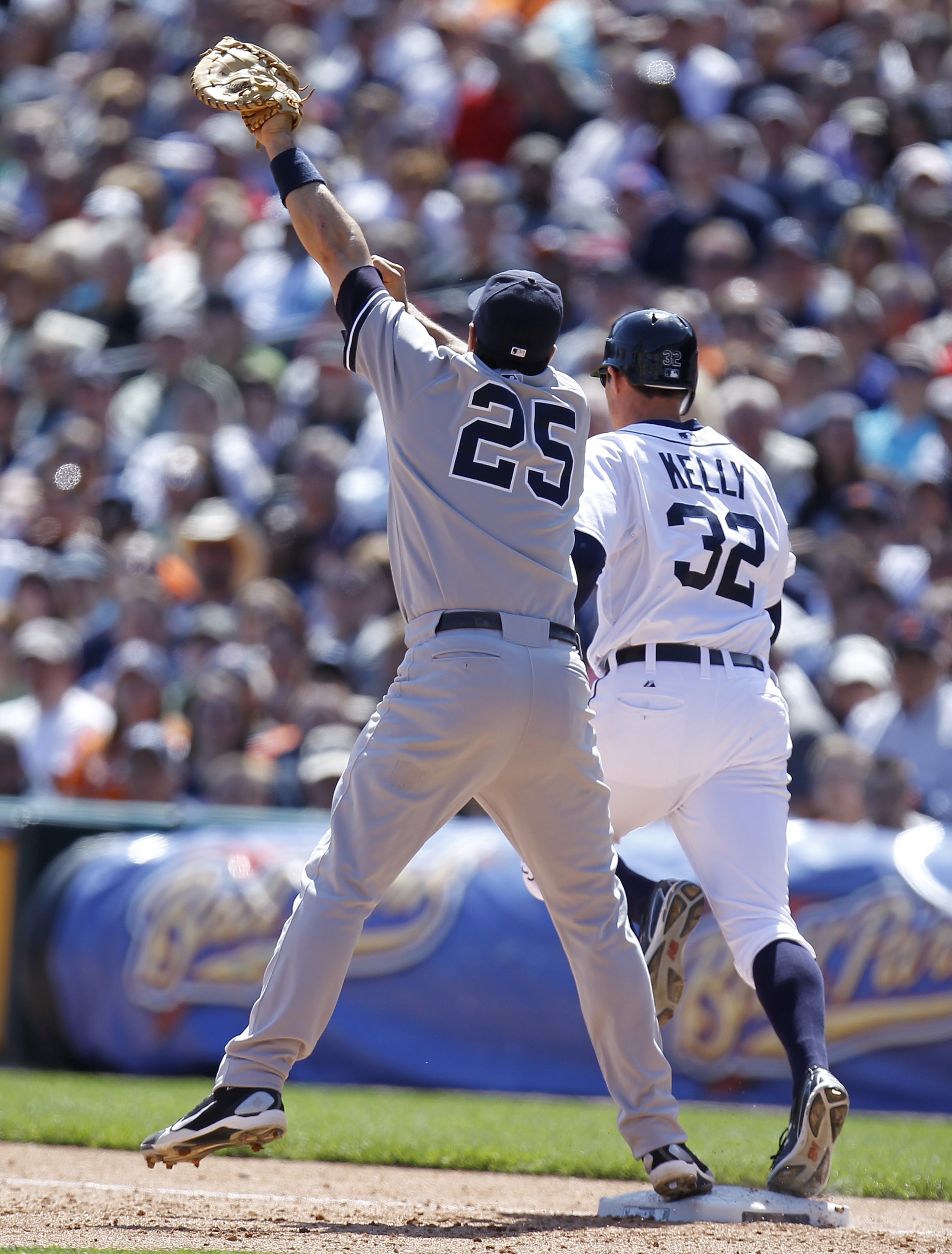 DETROIT, MI - MAY 05: Mark Teixeira #25 of the New York Yankees watches the ball go over his head from a throw by Eduardo Nunez #26 in front of Don Kelly #32 of the Detroit Tigers in the seventh inning at Comerica Park on May 5, 2011 in Detroit, Michigan.