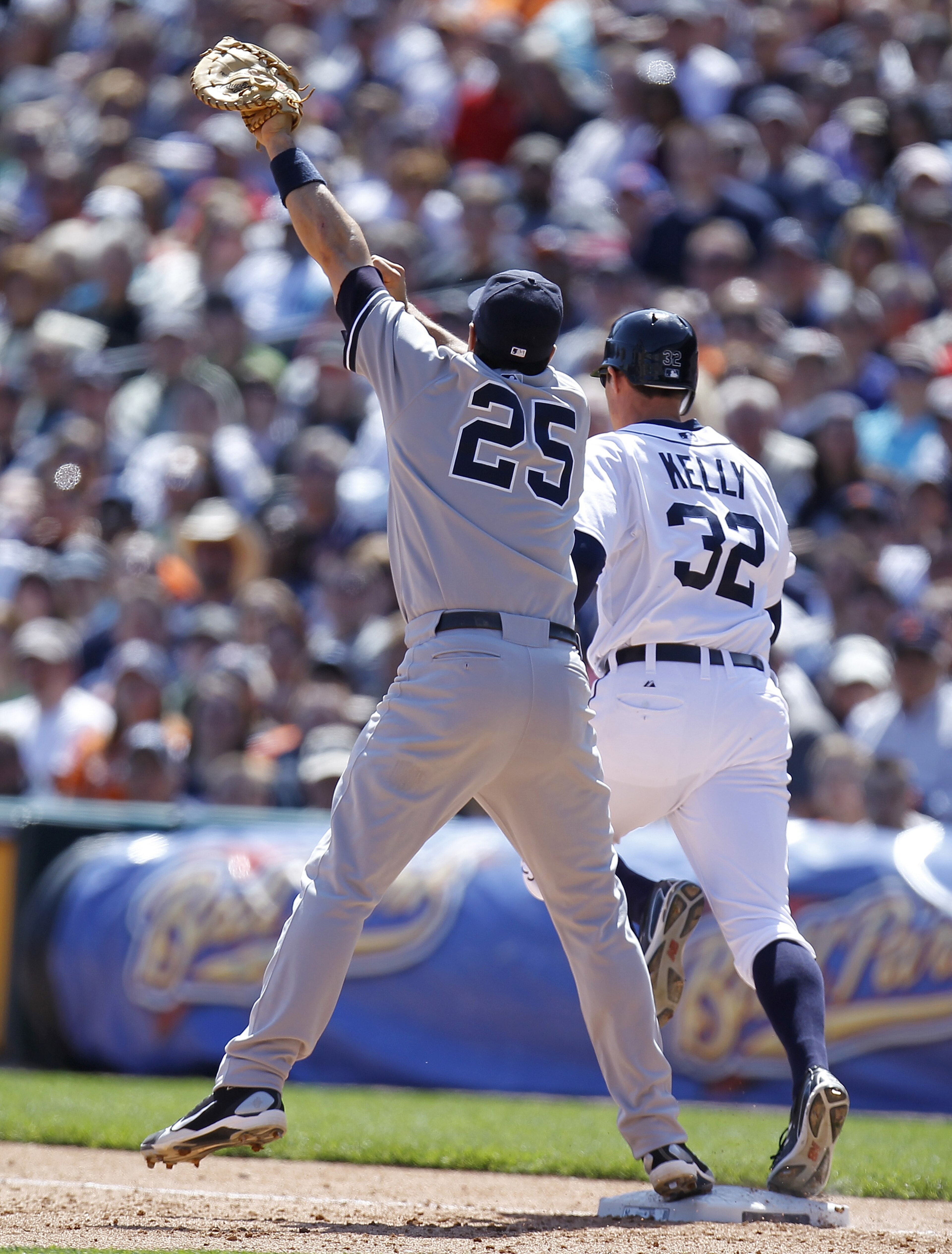 DETROIT, MI - MAY 05: Mark Teixeira #25 of the New York Yankees watches the ball go over his head from a throw by Eduardo Nunez #26 in front of Don Kelly #32 of the Detroit Tigers in the seventh inning at Comerica Park on May 5, 2011 in Detroit, Michigan.