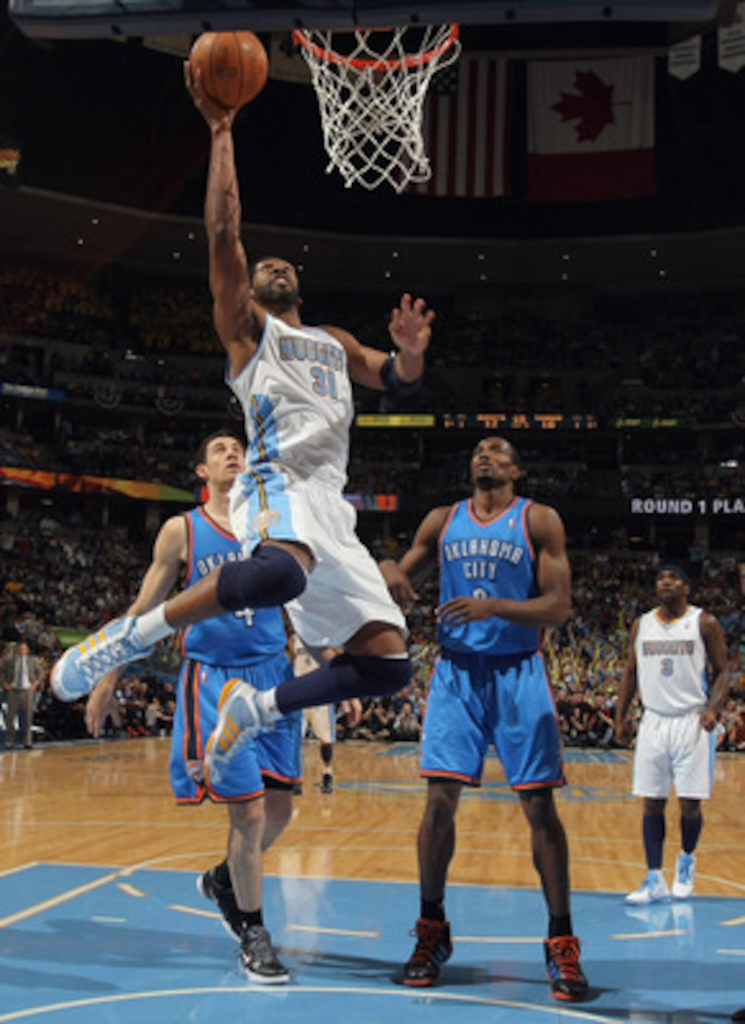 DENVER, CO - APRIL 23:  Nene Hilario #31 of the Denver Nuggets lays up a shot in front of Nick Collison #4 and Serge Ibaka #9 of the Oklahoma City Thunder in Game Three of the Western Conference Quarterfinals in the 2011 NBA Playoffs on April 23, 2011 at