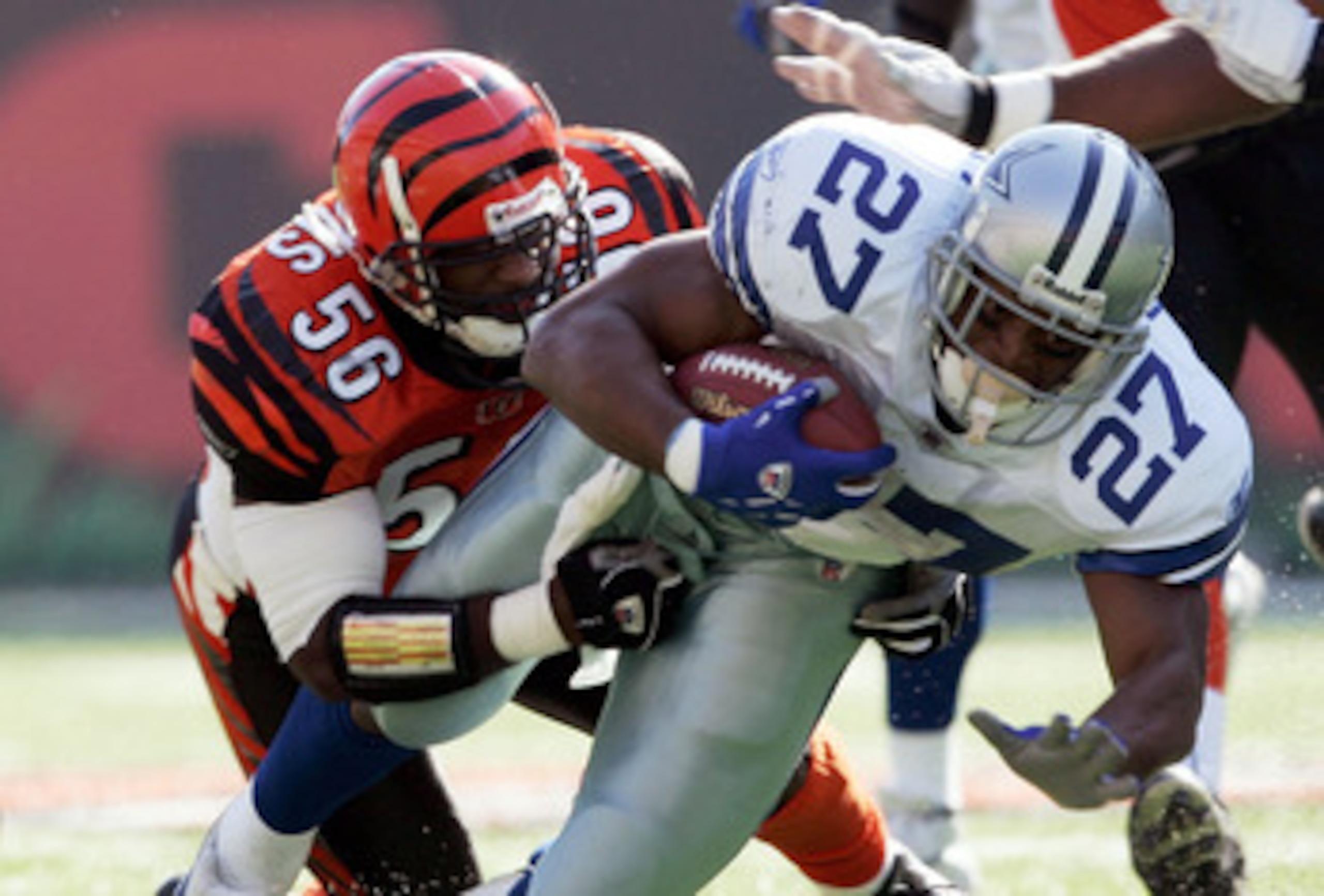 CINCINNATI - NOVEMBER 7:  Brian Simmons #56 of the Cincinnati Bengals tackles Eddie George #27 of the Dallas Cowboys at Paul Brown Stadium November 7, 2004 in Cincinnati, Ohio. Cincinnati won 26-3.  (Photo by Andy Lyons/Getty Images)