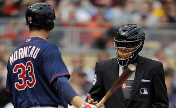 MINNEAPOLIS, MN - APRIL 13: Justin Morneau #33 of the Minnesota Twins speaks with home plate umpire Ed Hickox #15 during the seventh inning of their game against Kansas City Royals on April 13, 2011 at Target Field in Minneapolis, Minnesota. Royals defeat
