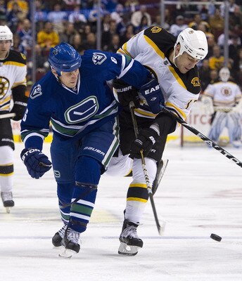 VANCOUVER, CANADA - FEBRUARY 26: Sami Salo #6 of the Vancouver Canucks ties up Milan Lucic #17 of the Boston Bruins during the first period in NHL action on February 26, 2011 at Rogers Arena in Vancouver, British Columbia, Canada.  (Photo by Rich Lam/Gett