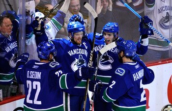 VANCOUVER, CANADA - MAY 24:  (L-R) Daniel Sedin #22, Henrik Sedin #33, Alex Burrows #14 and Dan Hamhuis #2 of the Vancouver Canucks celebrate Burrows' first period goal in Game Five of the Western Conference Finals against the San Jose Sharks during the 2