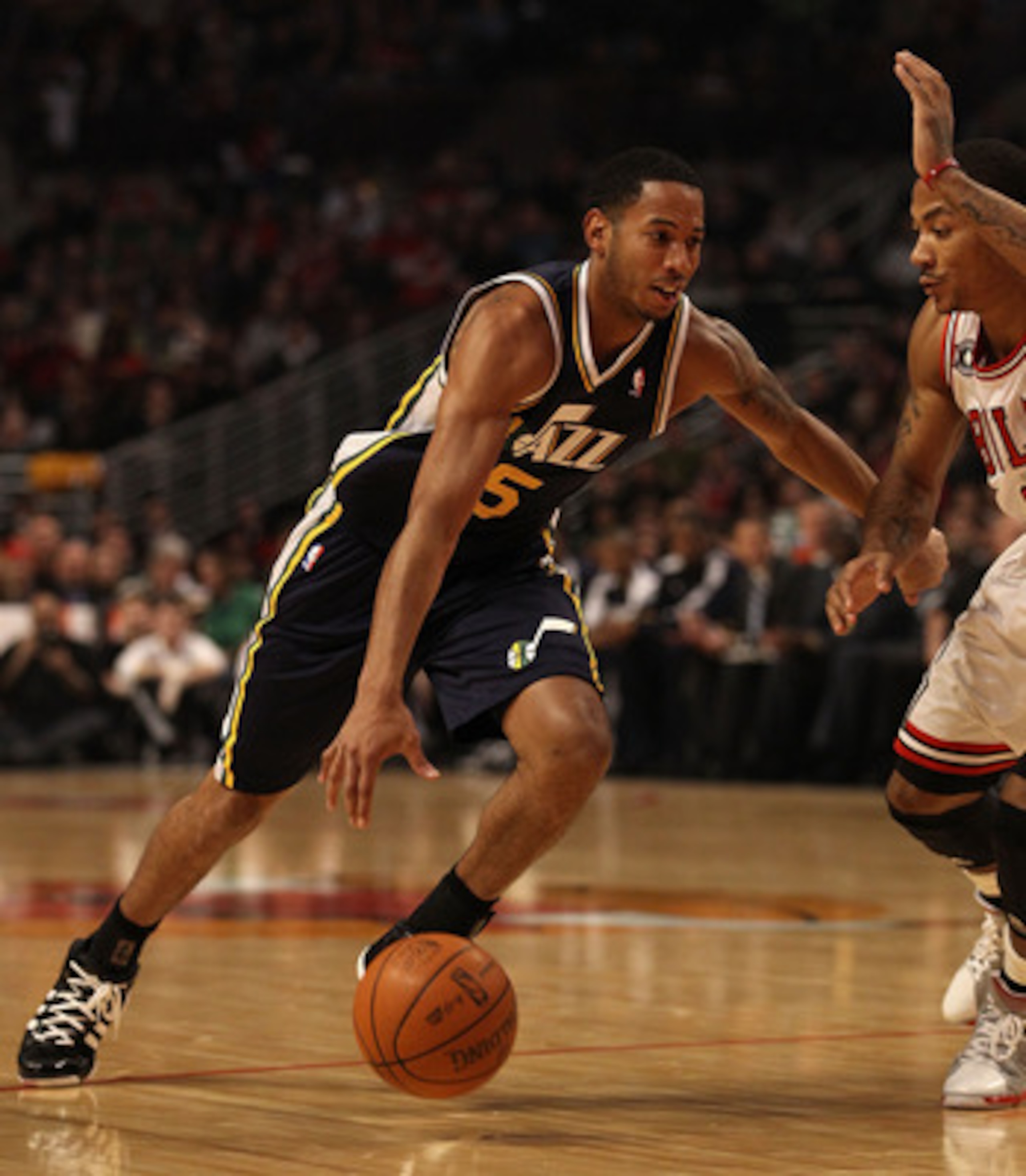CHICAGO, IL - MARCH 12: Devin Harris #5 of the Utah Jazz drives against Derrick Rose #1 of the Chicago Bulls at the United Center on March 12, 2011 in Chicago, Illinois. The Bulls defeated the Jazz 118-100. NOTE TO USER: User expressly acknowledges and ag CHICAGO, IL - MARCH 12: Devin Harris #5 of the Utah Jazz drives against Derrick Rose #1 of the Chicago Bulls at the United Center on March 12, 2011 in Chicago, Illinois. The Bulls defeated the Jazz 118-100. NOTE TO USER: User expressly acknowledges and ag