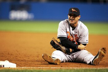 NEW YORK - SEPTEMBER 20:  Brian Roberts #1 of the Baltimore Orioles holds his arm after a collision at first base attempting to tag out Bubba Crosby #18 of the New York Yankees on September 20, 2005 in the Bronx Borough of New York City. Roberts left the