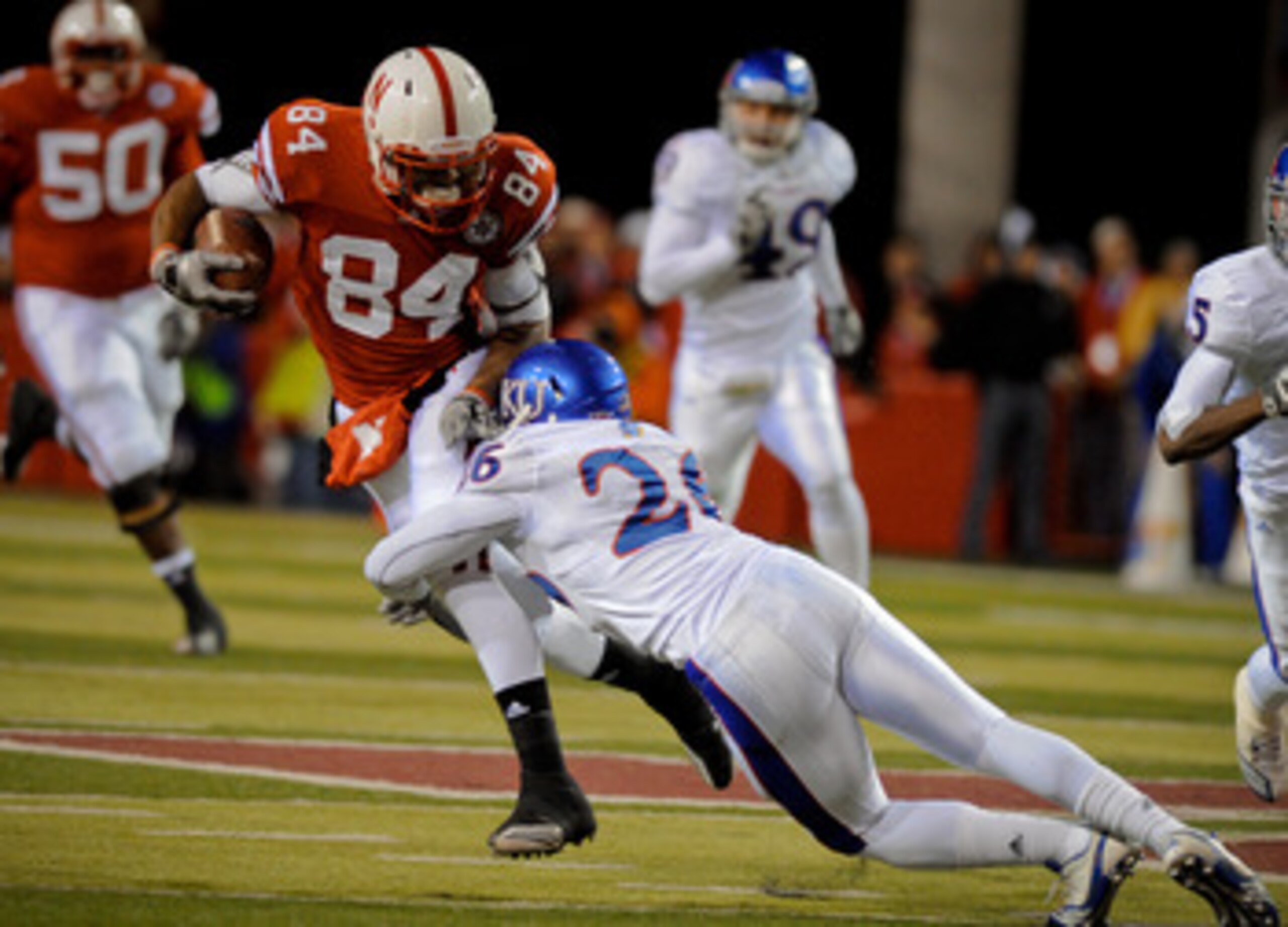 LINCOLN, NE - NOVEMBER 13: Brandon Kinnie #84 of the Nebraska Cornhuskers tries to avoid Phillip Strozier #26 of the Kansas Jayhawks during first half action of their game at Memorial Stadium on November 13, 2010 in Lincoln, Nebraska. (Photo by Eric Franc LINCOLN, NE - NOVEMBER 13: Brandon Kinnie #84 of the Nebraska Cornhuskers tries to avoid Phillip Strozier #26 of the Kansas Jayhawks during first half action of their game at Memorial Stadium on November 13, 2010 in Lincoln, Nebraska. (Photo by Eric Franc