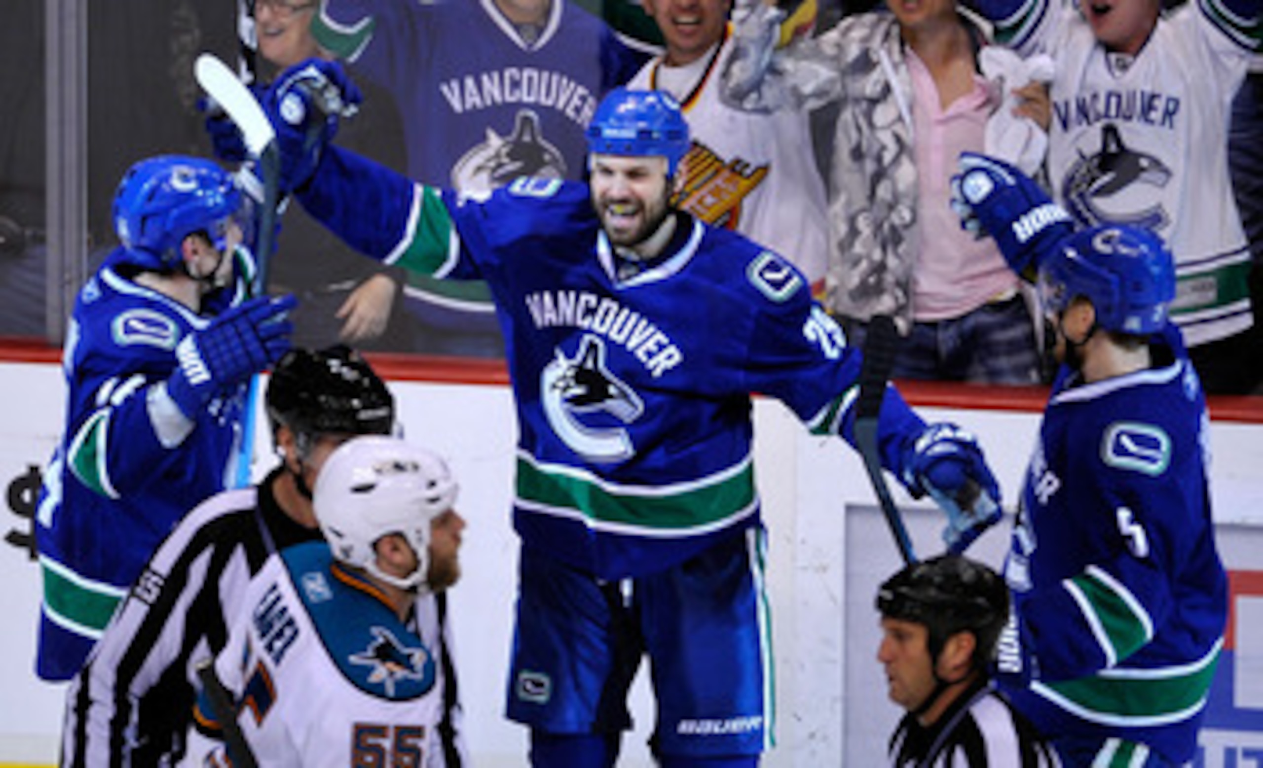VANCOUVER, CANADA - MAY 18:  Aaron Rome #29 of the Vancouver Canucks celebrates his third period goal with teammates Alex Burrows #14 and Christian Ehrhoff #5 as Ben Eager #55 of the San Jose Sharks skates by in Game Two of the Western Conference Finals d