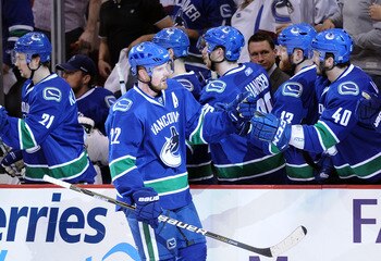 VANCOUVER, CANADA - MAY 18:  Daniel Sedin #22 of the Vancouver Canucks skates by the Canucks bench to celebrate his first period goal with teammates in Game Two of the Western Conference Finals against the San Jose Sharks during the 2011 Stanley Cup Playo
