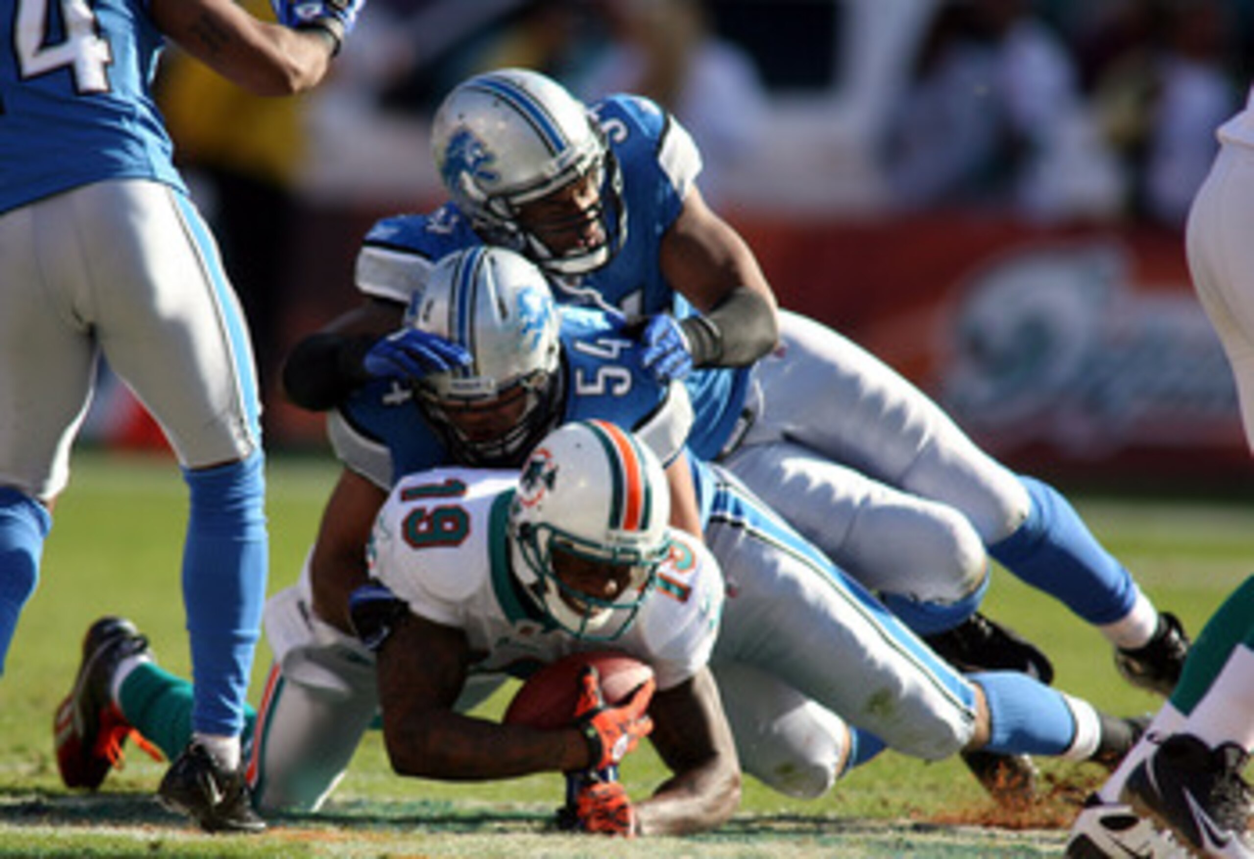MIAMI - DECEMBER 26: Wide receiver Brandon Marshall #19 of the Miami Dolphins is brought down by linebacker DeAndre Levy #54 of the Detroit Lions at Sun Life Stadium on December 26, 2010 in Miami, Florida. The Lions defeated the Dolphins 34-27. (Photo by MIAMI - DECEMBER 26: Wide receiver Brandon Marshall #19 of the Miami Dolphins is brought down by linebacker DeAndre Levy #54 of the Detroit Lions at Sun Life Stadium on December 26, 2010 in Miami, Florida. The Lions defeated the Dolphins 34-27. (Photo by