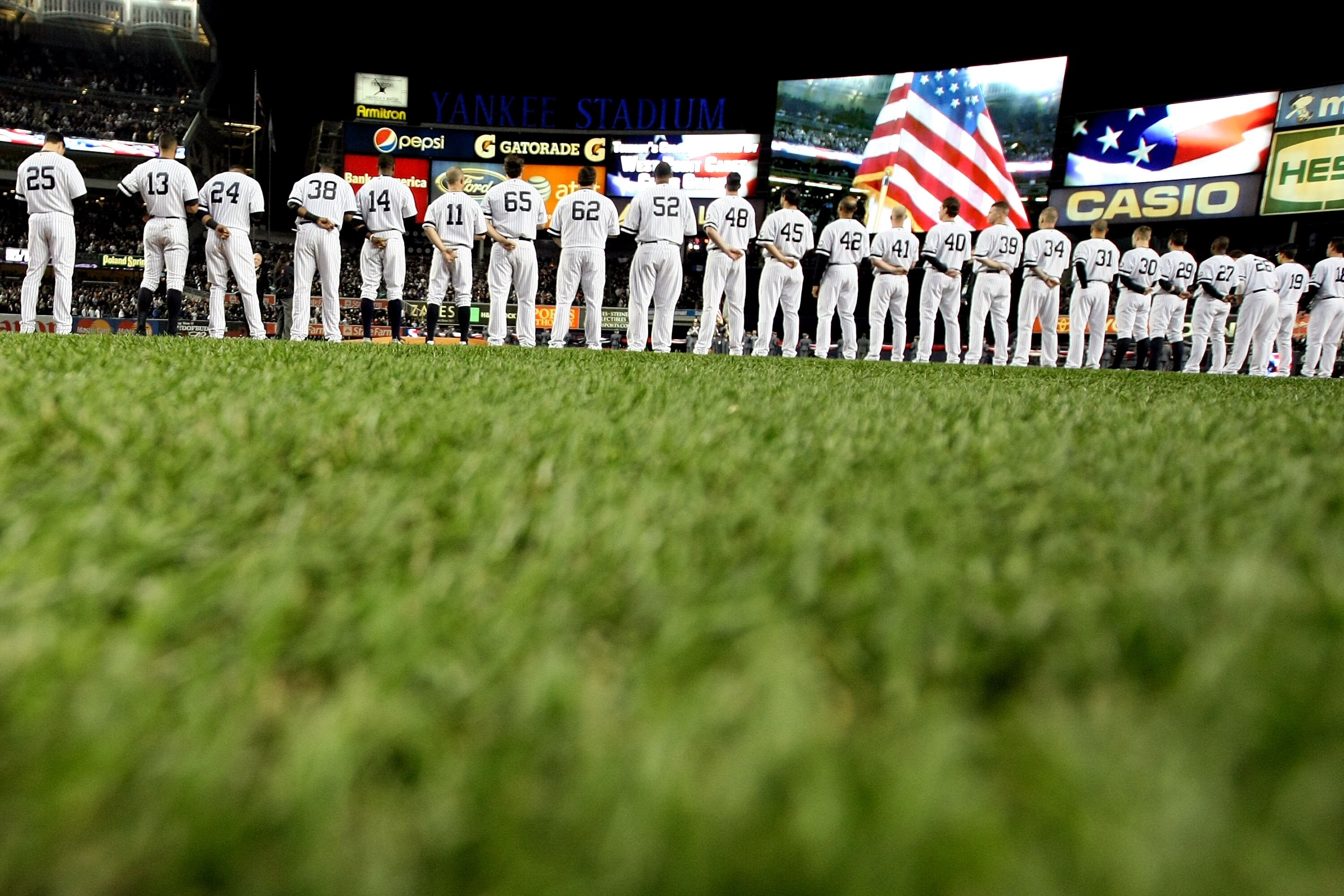 NEW YORK - OCTOBER 18:  The American Flag is seen on the video screen during the National Anthem as the Yankees and Texas Rangers stand on the foul lines prior to playing in Game Three of the ALCS during the 2010 MLB Playoffs at Yankee Stadium on October