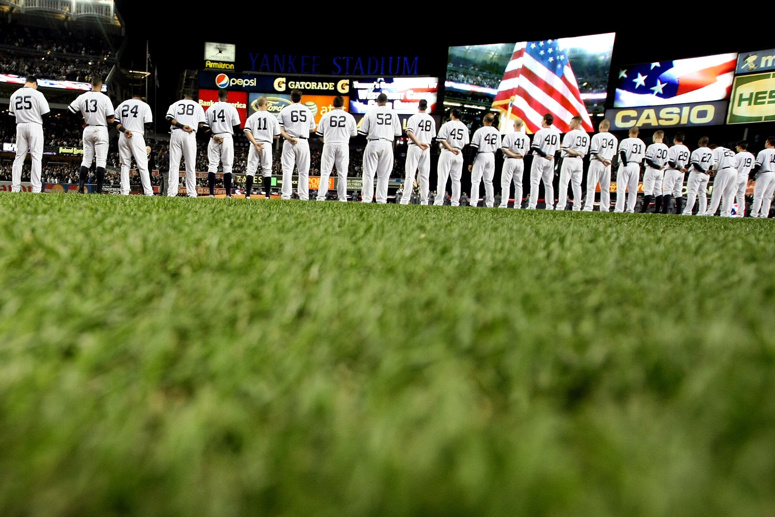 NEW YORK - OCTOBER 18:  The American Flag is seen on the video screen during the National Anthem as the Yankees and Texas Rangers stand on the foul lines prior to playing in Game Three of the ALCS during the 2010 MLB Playoffs at Yankee Stadium on October
