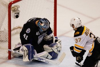 TAMPA, FL - MAY 21:  Mike Smith #41 of the Tampa Bay Lightning makes a save as Patrice Bergeron #37 of the Boston Bruins looks on in Game Four of the Eastern Conference Finals during the 2011 NHL Stanley Cup Playoffs at St Pete Times Forum on May 21, 2011