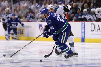 VANCOUVER, CANADA - MAY 24:  Joe Pavelski #8 of the San Jose Sharks pokes the puck past Henrik Sedin #33 of the Vancouver Canucks in the third period in Game Five of the Western Conference Finals during the 2011 Stanley Cup Playoffs at Rogers Arena on May