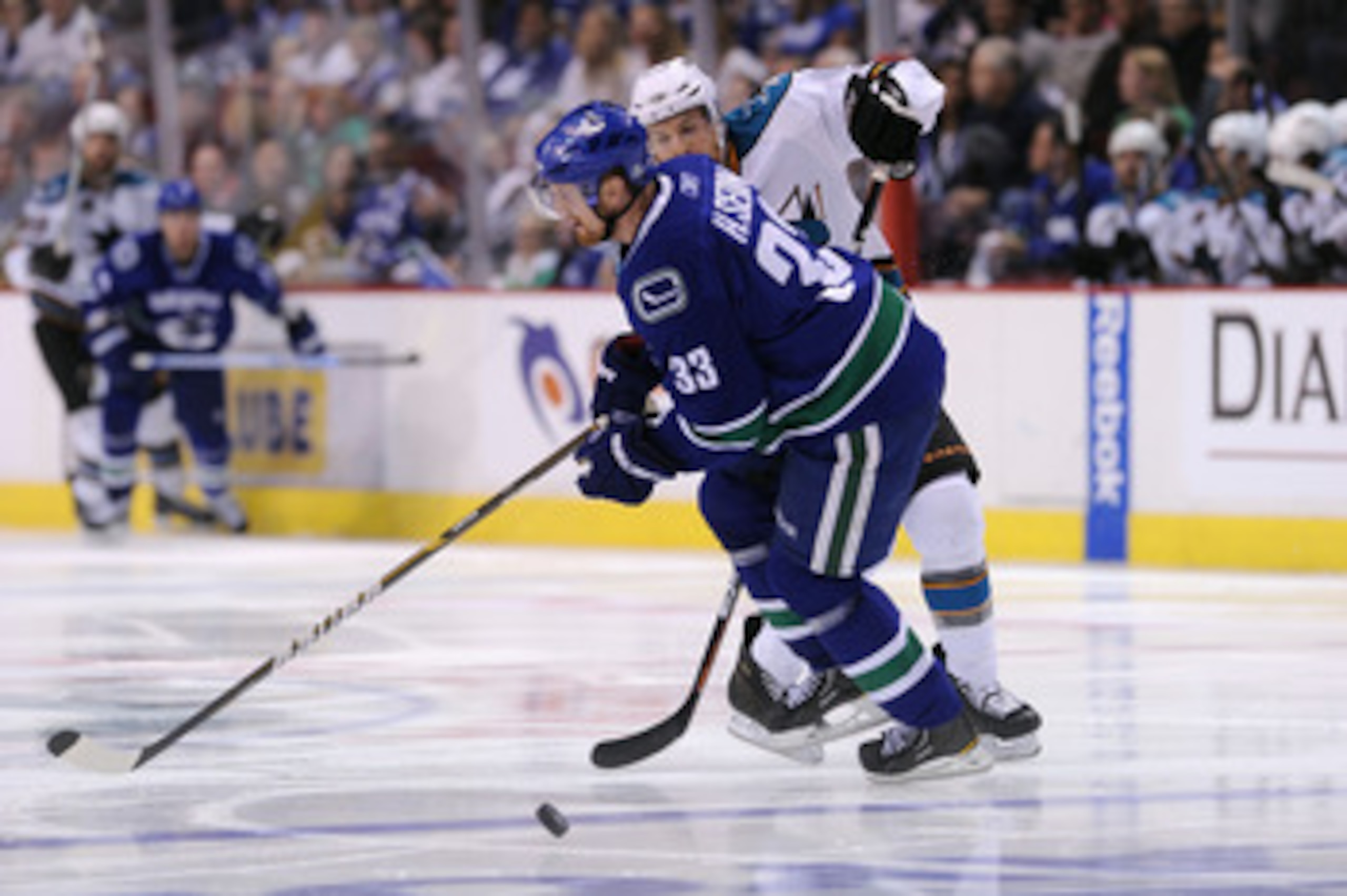 VANCOUVER, CANADA - MAY 24:  Joe Pavelski #8 of the San Jose Sharks pokes the puck past Henrik Sedin #33 of the Vancouver Canucks in the third period in Game Five of the Western Conference Finals during the 2011 Stanley Cup Playoffs at Rogers Arena on May