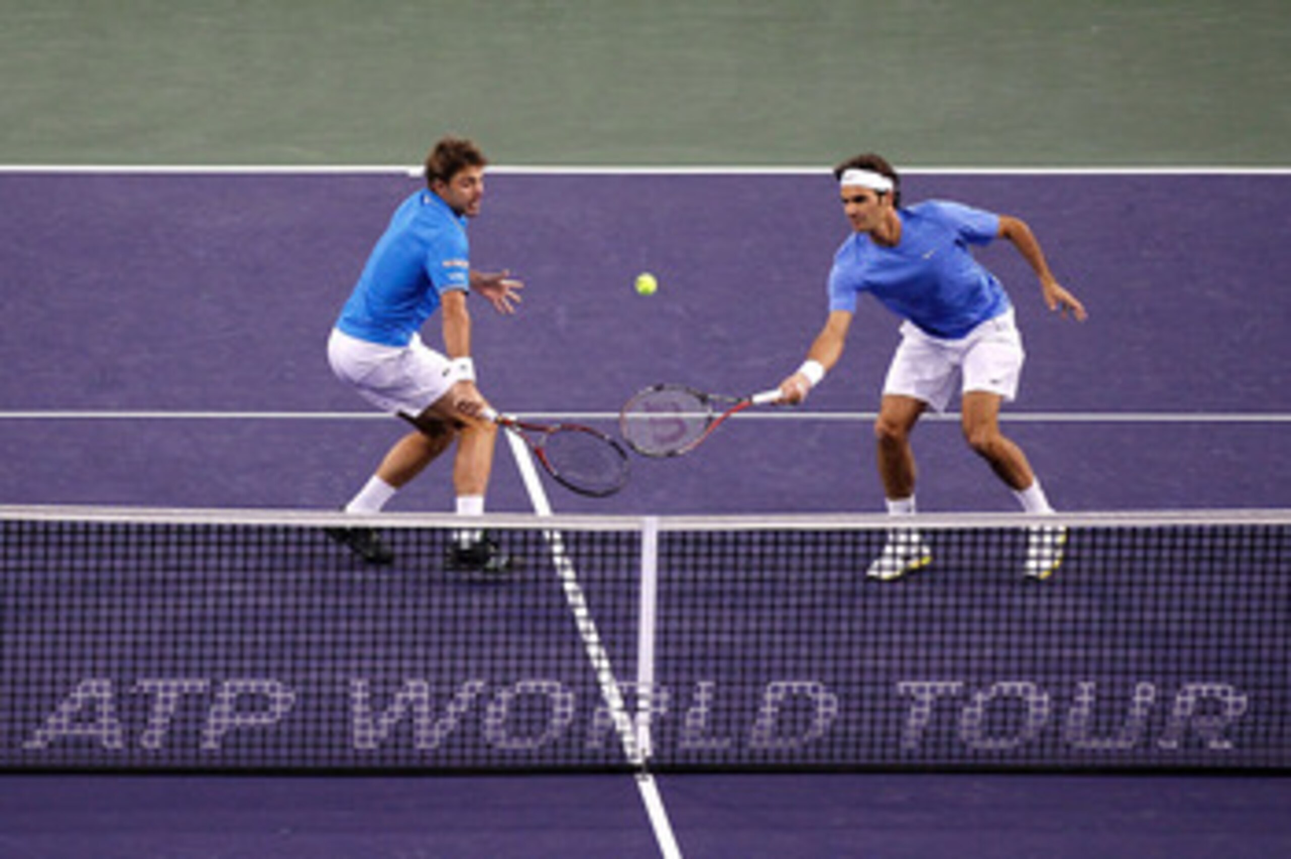 INDIAN WELLS, CA - MARCH 19:  Stanilas Wawrinka and Roger Federer of Switzerland play Xavier Malisse of Belgium and Alexandr Dolgopolov of the Ukraine during the doubles final of the BNP Paribas Open at the Indian Wells Tennis Garden on March 19, 2011 in