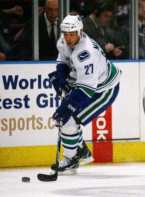 NEW YORK , NY - JANUARY 13: Manny Malhotra #27 of the Vancouver Canucks plays the puck against the New York Rangers during the game at Madison Square Garden on January 13, 2011 in New York City. (Photo by Andy Marlin/Getty Images)