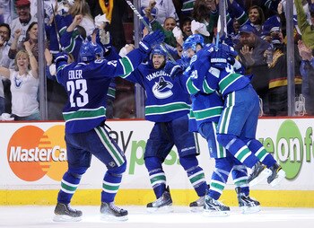 VANCOUVER, CANADA - MAY 24:  (L-R) Alexander Edler #23, Ryan Kesler #17, Alex Burrows #14 and Daniel Sedin #22 of the Vancouver Canucks celebrate Kesler's game tying goal with less than 14 seconds in the third period to send the game into overtime in Game