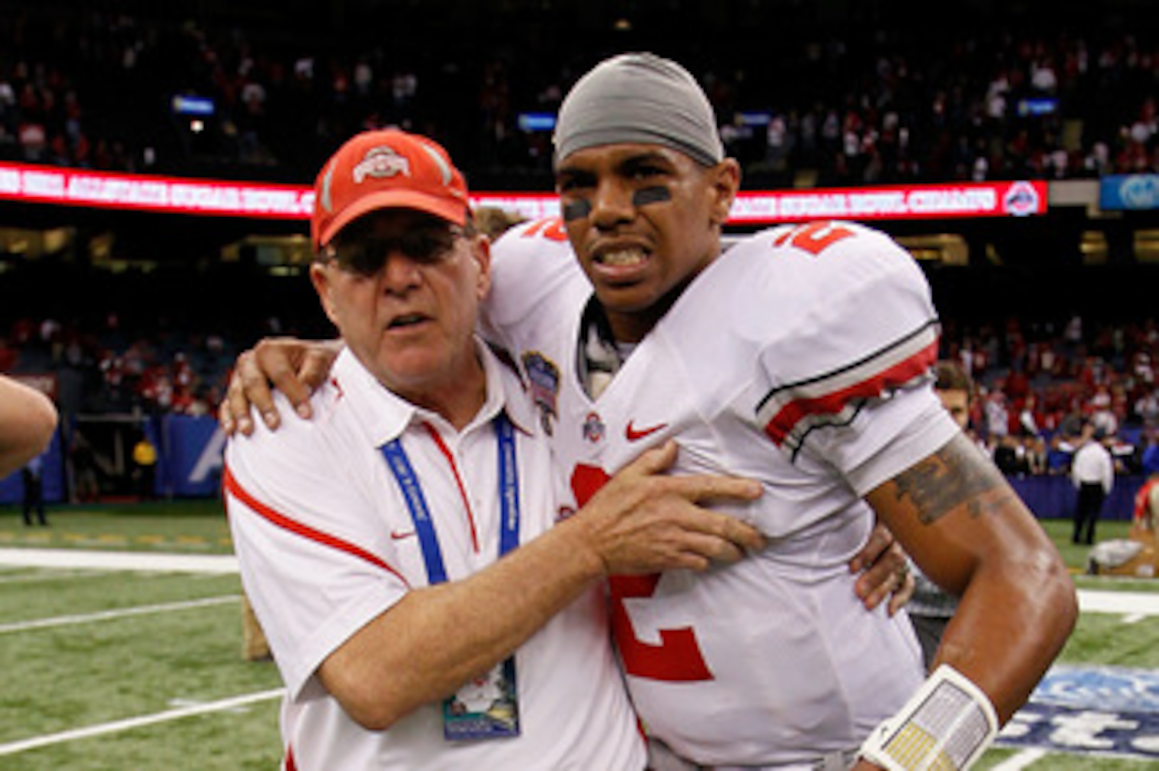 NEW ORLEANS, LA - JANUARY 04:  (M) Quarterback Terrelle Pryor #2 of the Ohio State Buckeyes is helped off the field by a member of the Buckeyes support team after the Buckeyes 31-26 victory against the Arkansas Razorbacks during the Allstate Sugar Bowl at